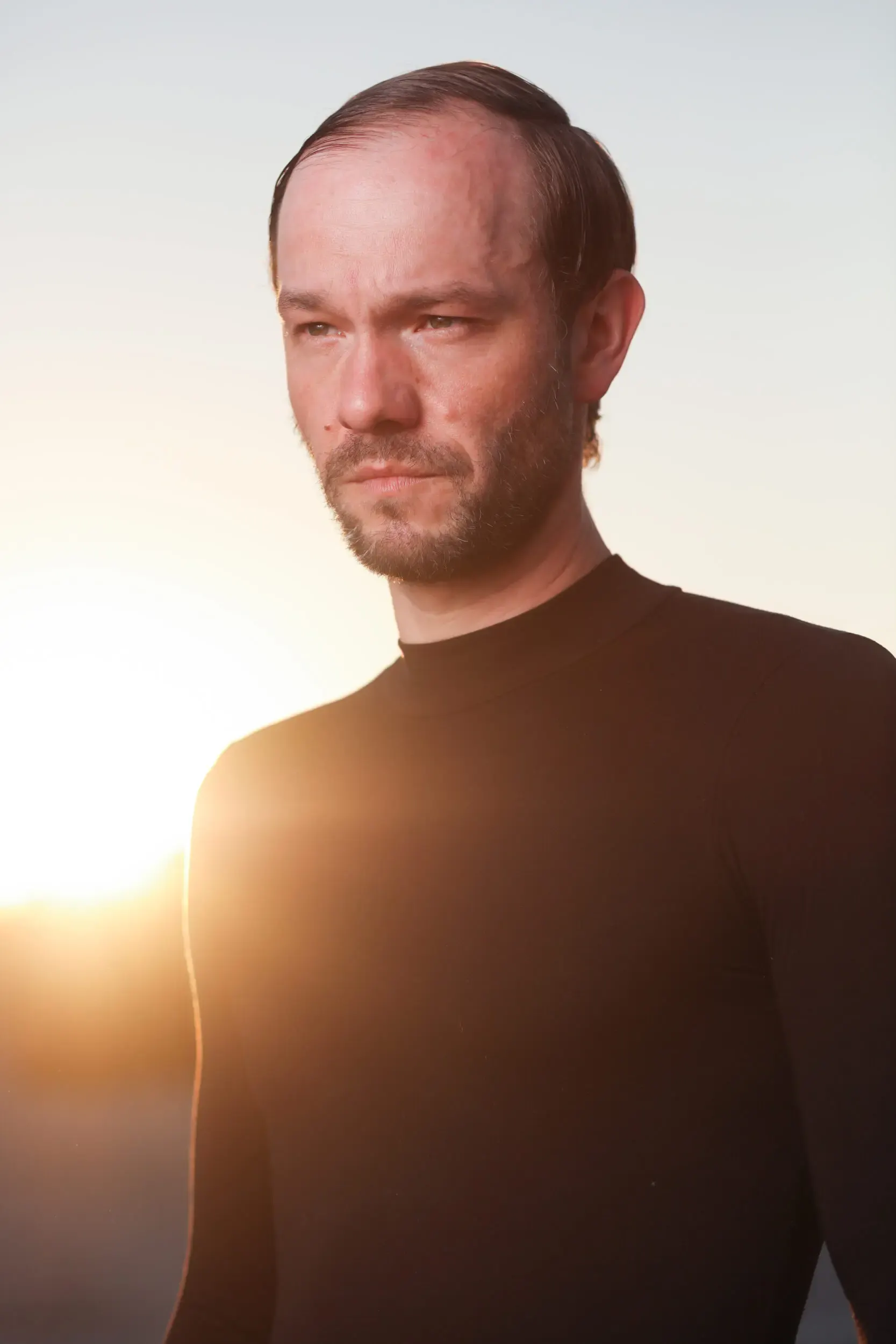 Portrait eines Mannes im Gegenlicht der untergehenden Sonne