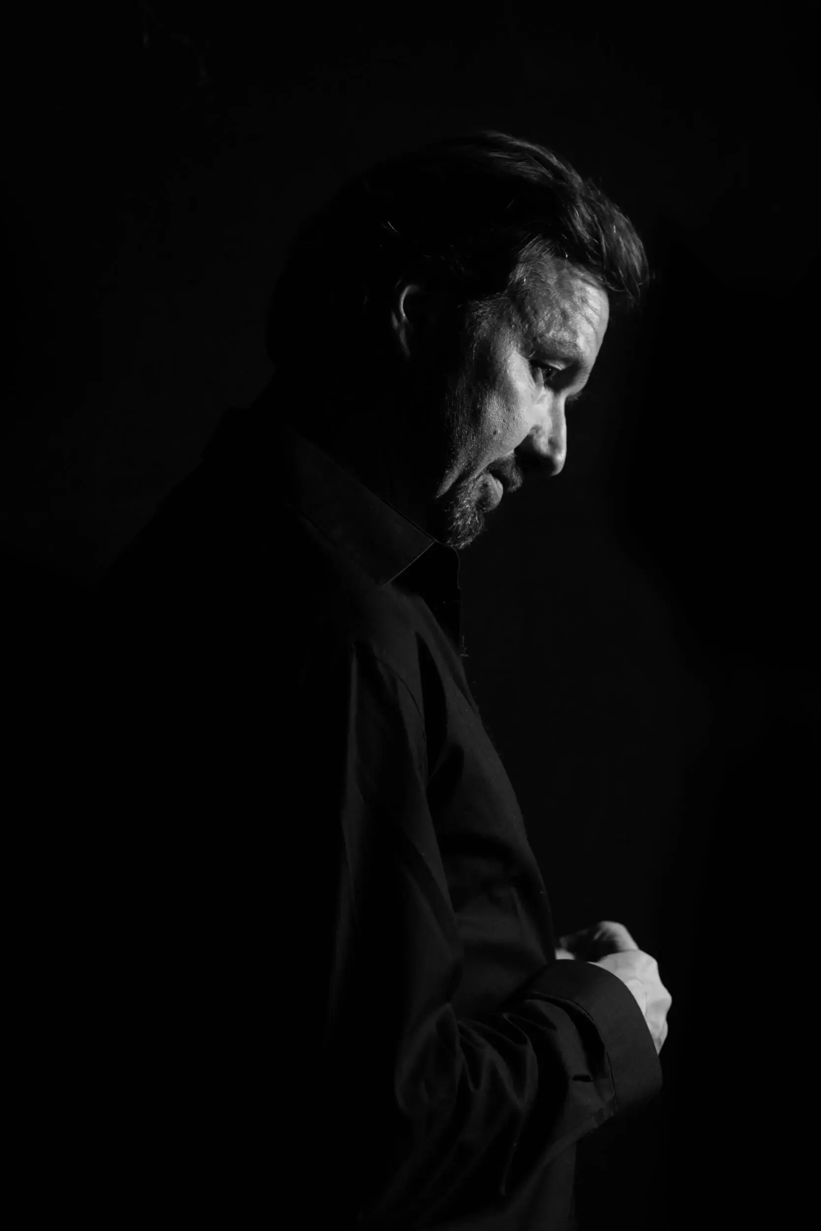 Dunkle Silhouette einer stehenden Person vor schwarzem Hintergrund