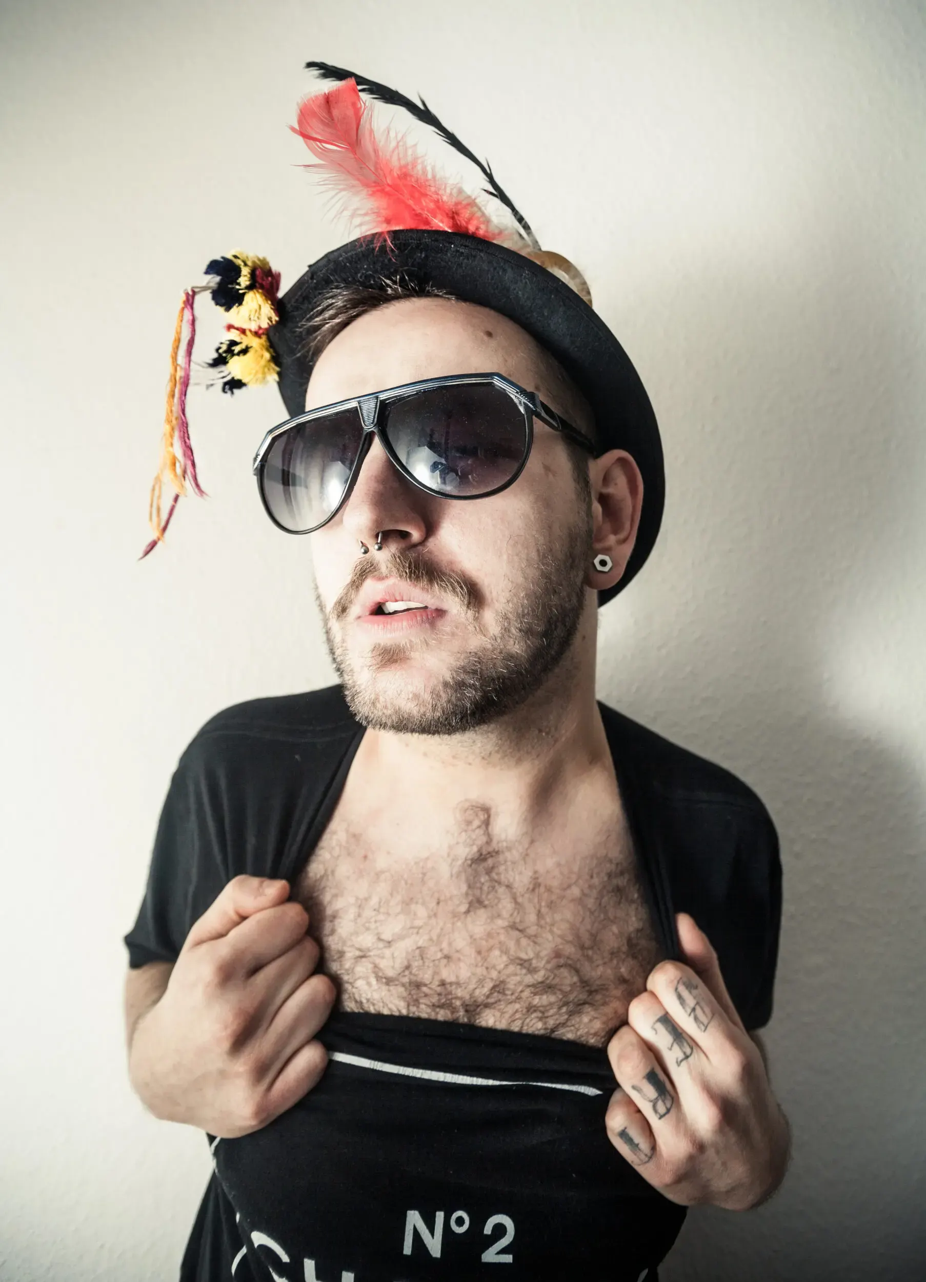 Portrait eines Mannes mit Federhut und Sonnenbrille
