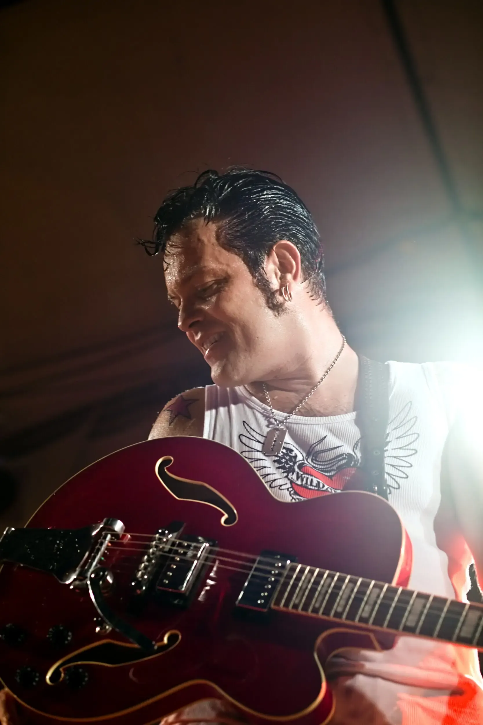 Musiker spielt E-Gitarre im roten Rauch