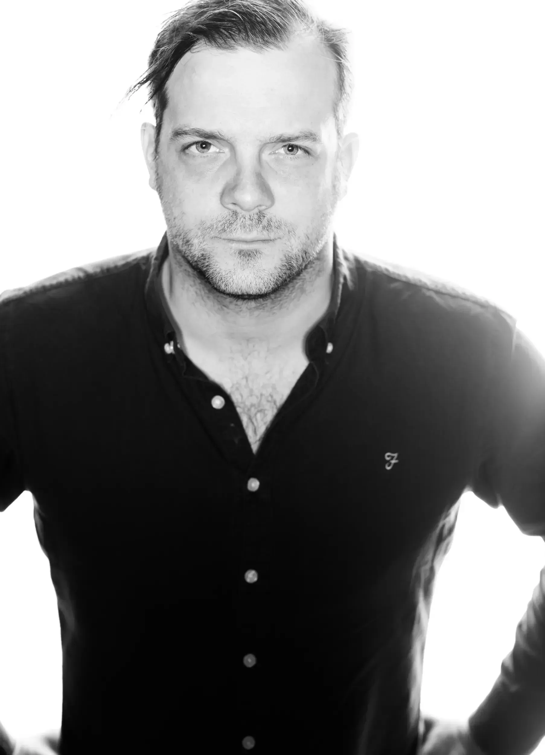 Black-and-white studio portrait of André Willmund in a dark shirt, looking directly at the camera.