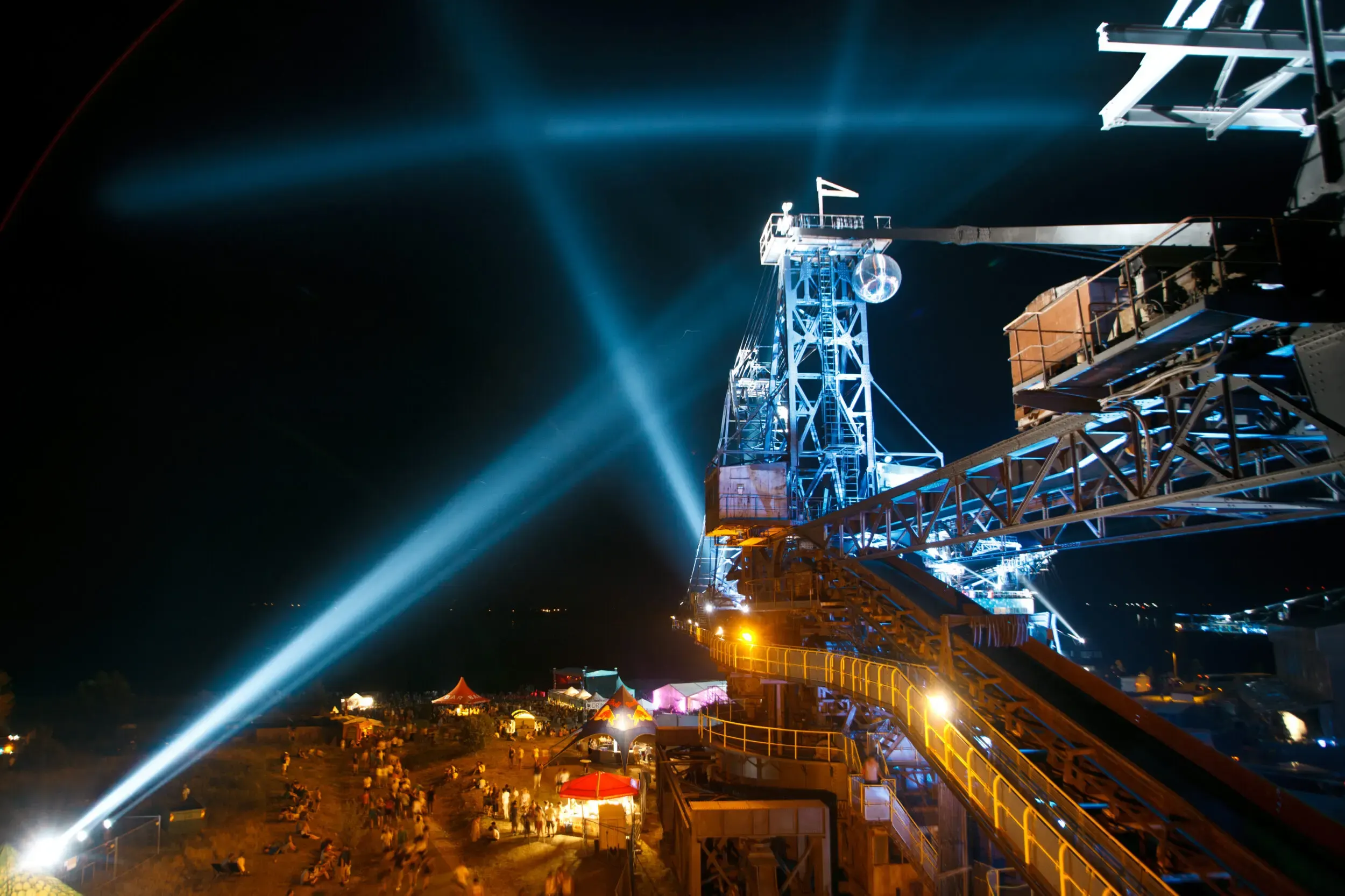 Festivalbühne mit blauen Laserlichtern bei Nacht