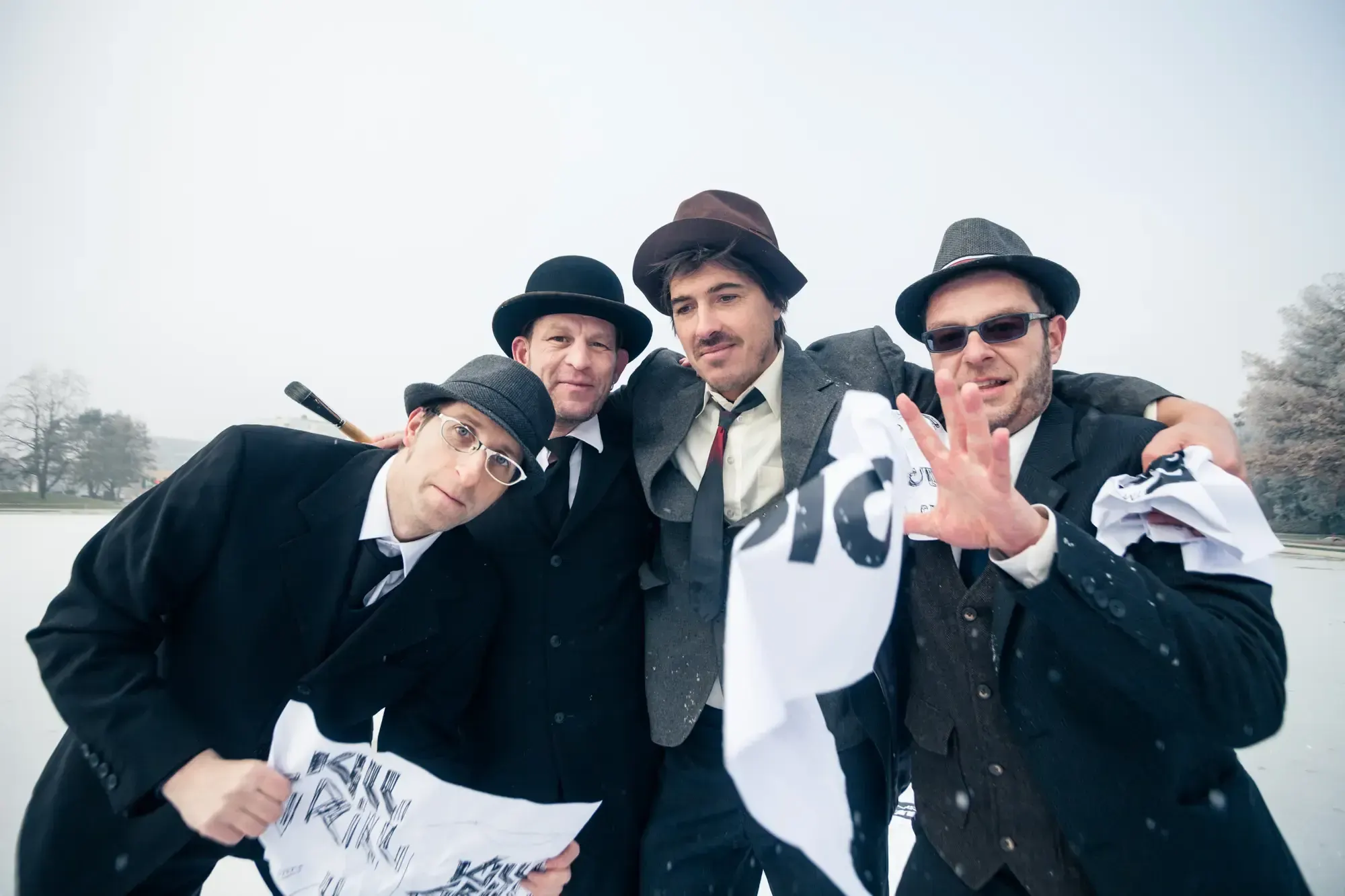 The Büro Destruct team huddled together in the snow, waving printed flags and smiling.