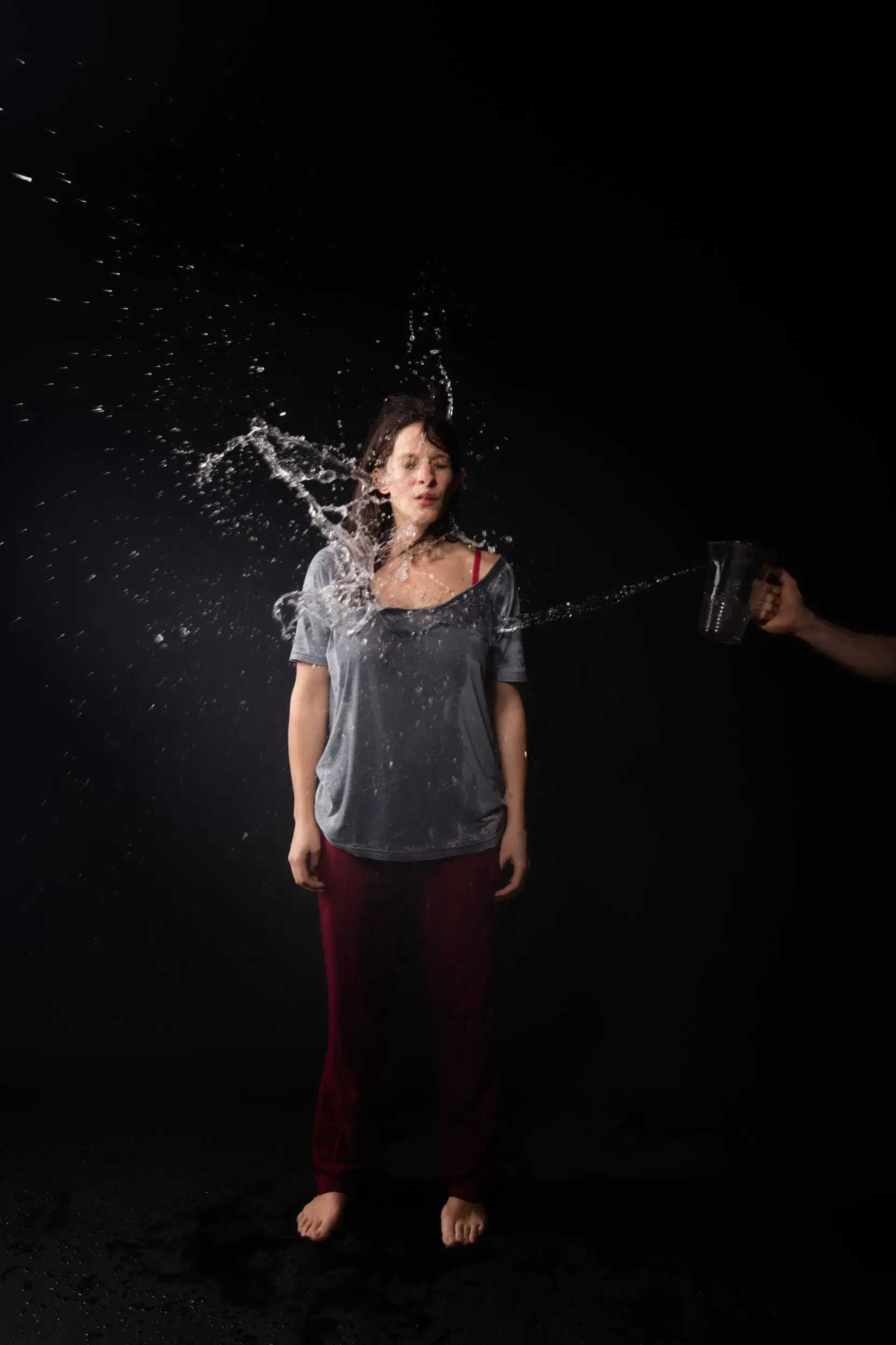 Actionportrait von Carolin Conrad mit Wasserspritzer vor schwarzem Hintergrund