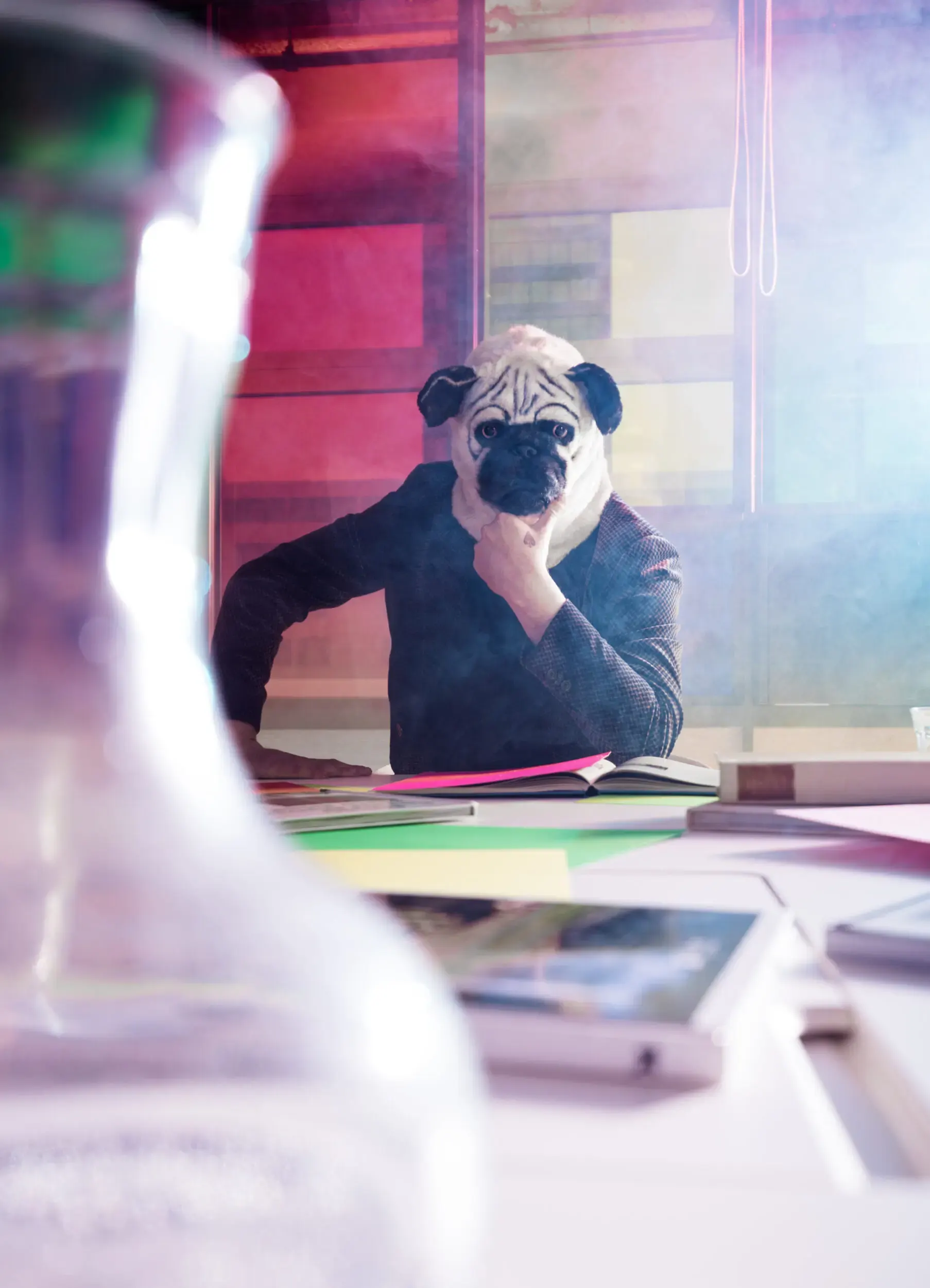 Guest in a baboon mask seated at an office desk, captured with motion blur.