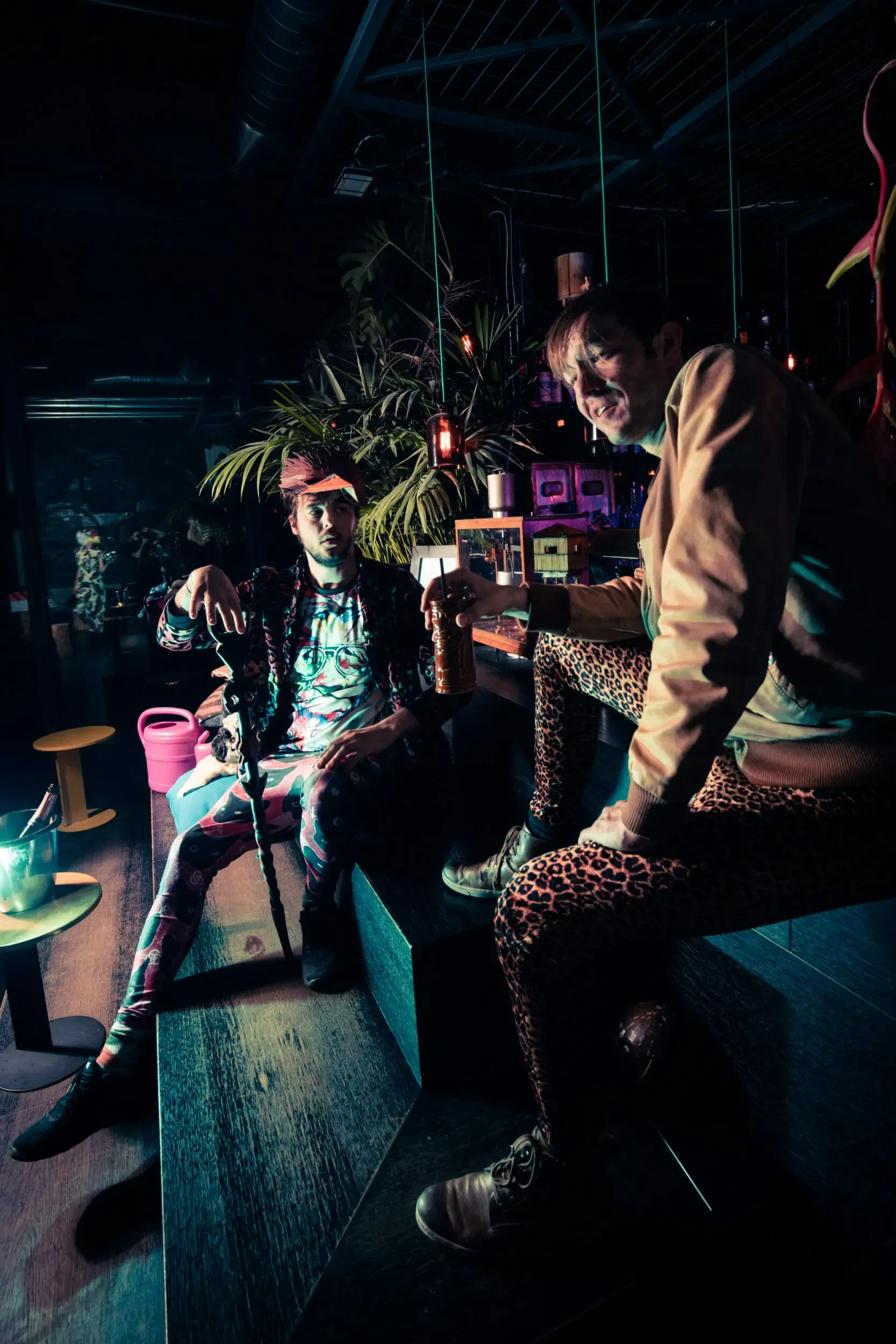 Costumed guests climbing and posing among wooden crates in a jungle-themed room.