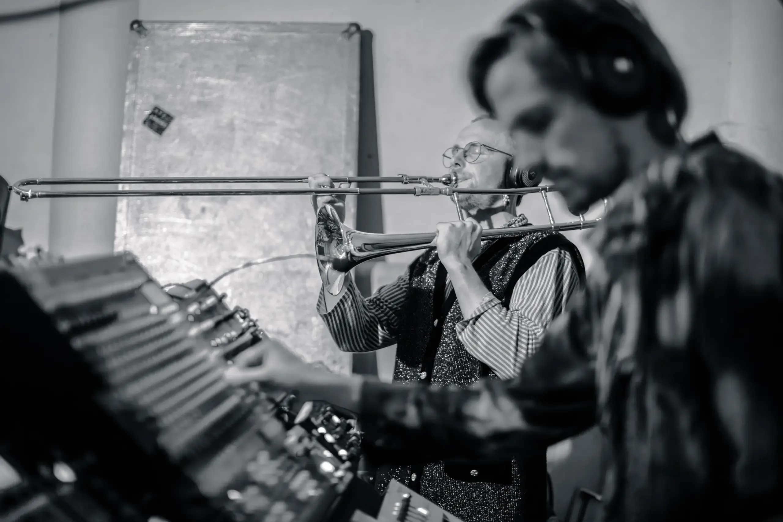 Schwarzweissfoto eines Musikers mit Kopfhörern beim Spielen eines Schlaginstruments, Eigenklang