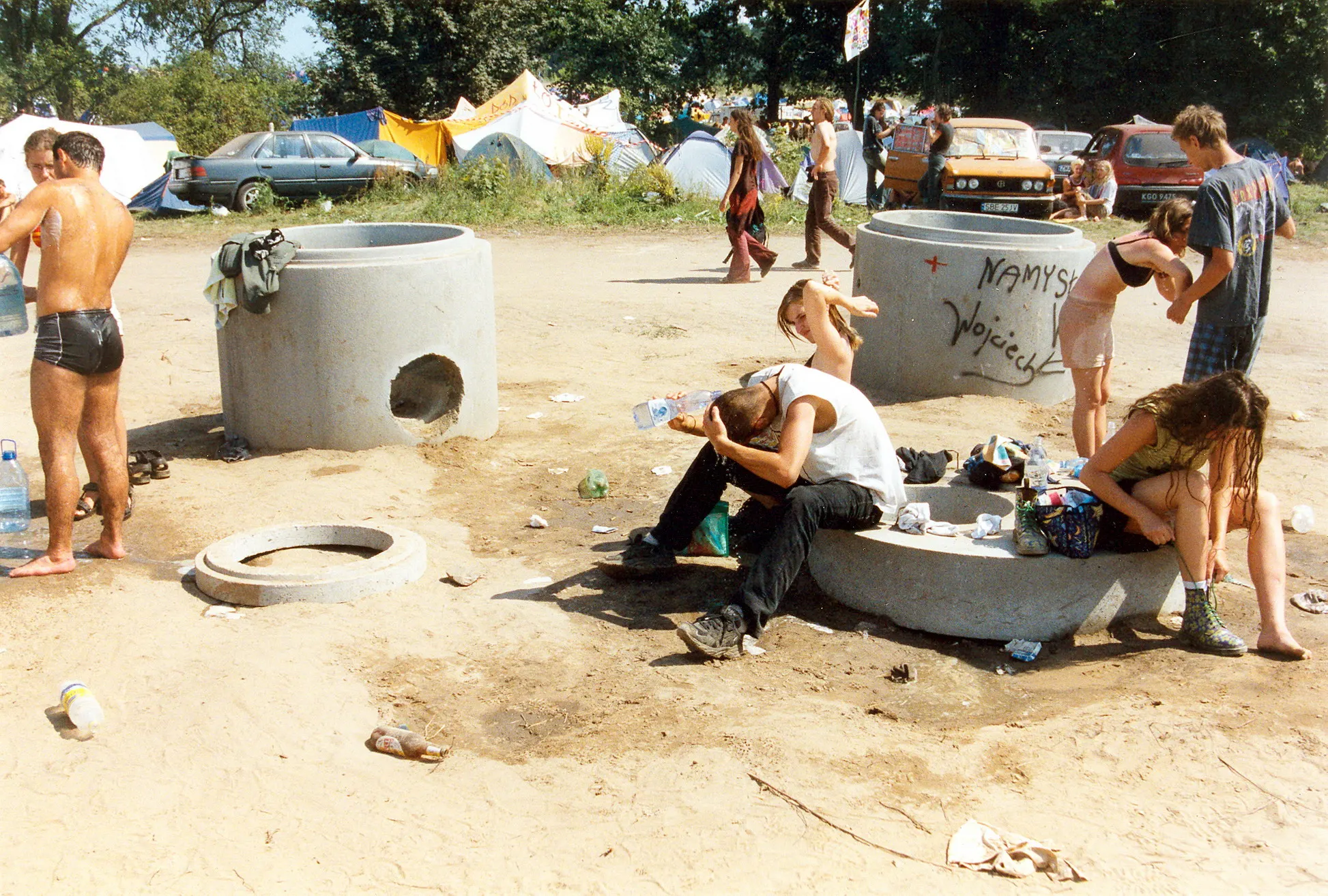 Festivalbesucher entspannen an einem Wasserbecken