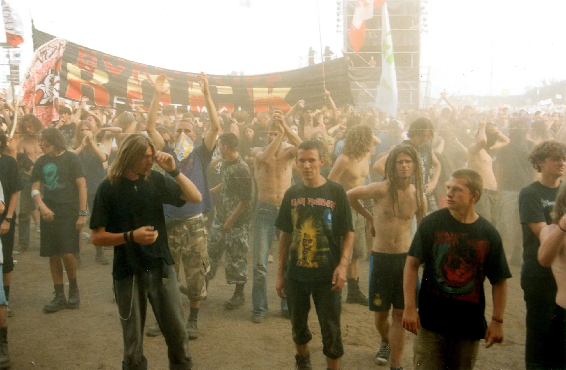 Festivalbesucher mit Fahnen gehen über das Gelände