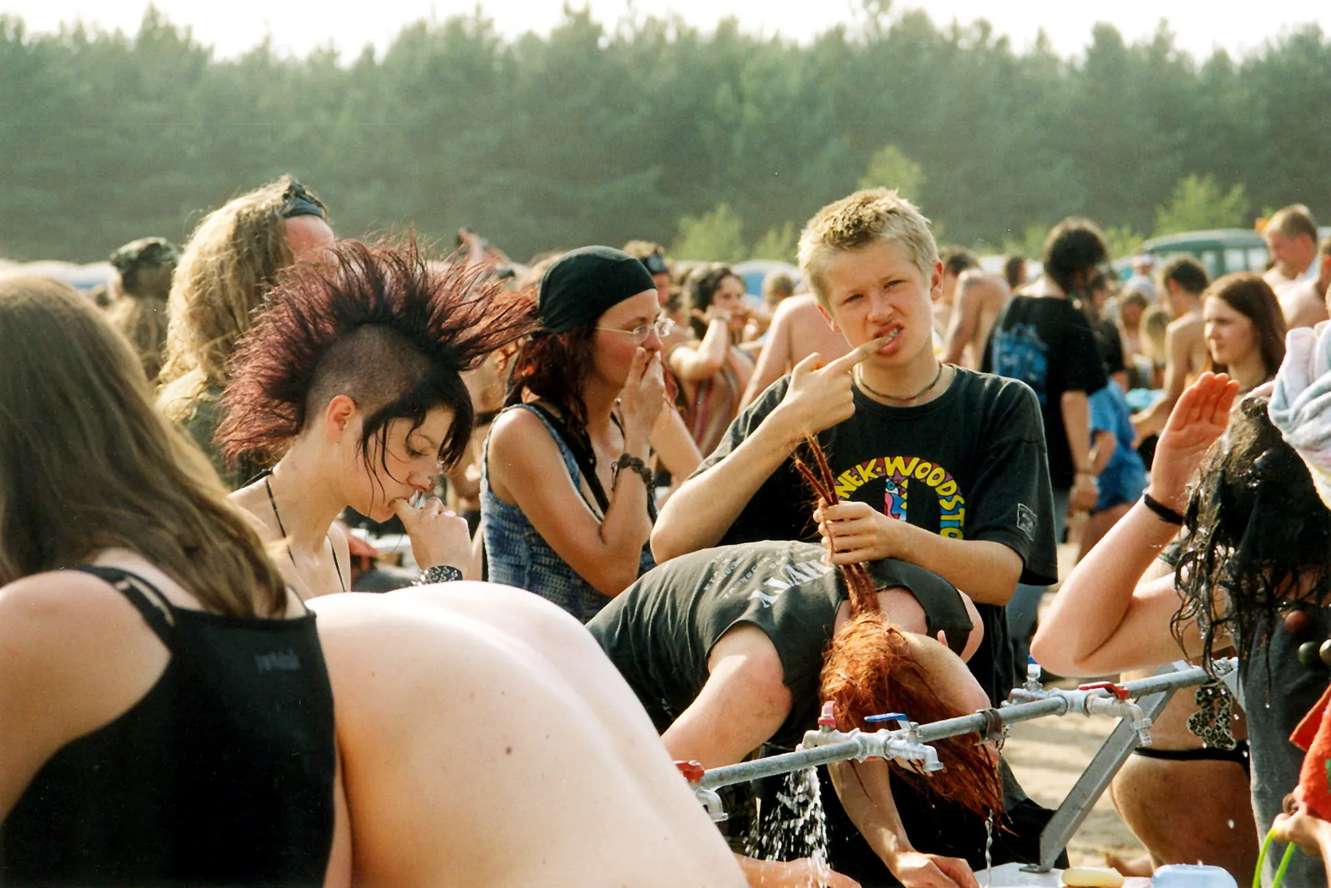 Festivalbesucher mit Irokesenschnitt sitzt inmitten der Menge