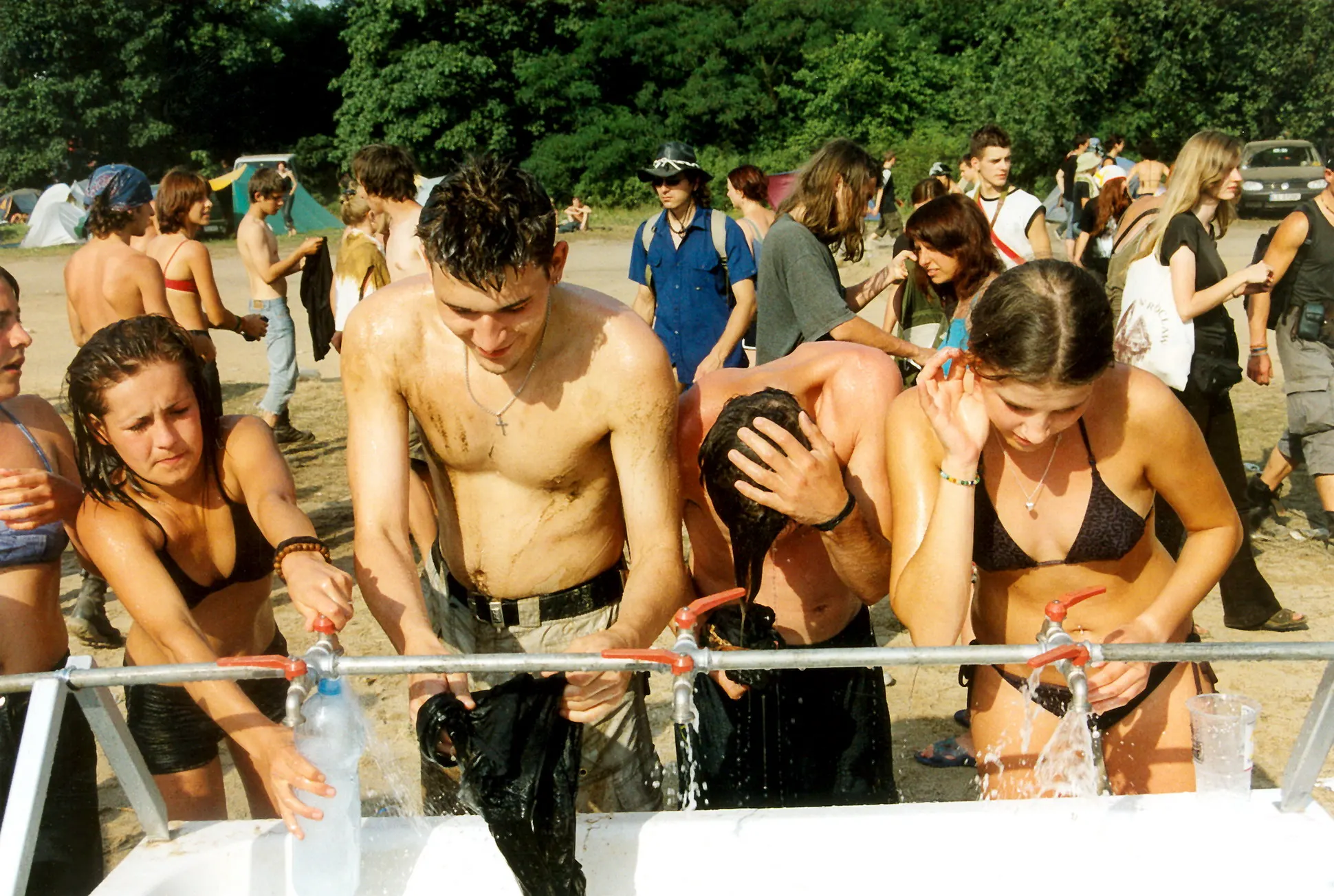 Festivalbesucher kühlen sich an einer Wasserstelle ab