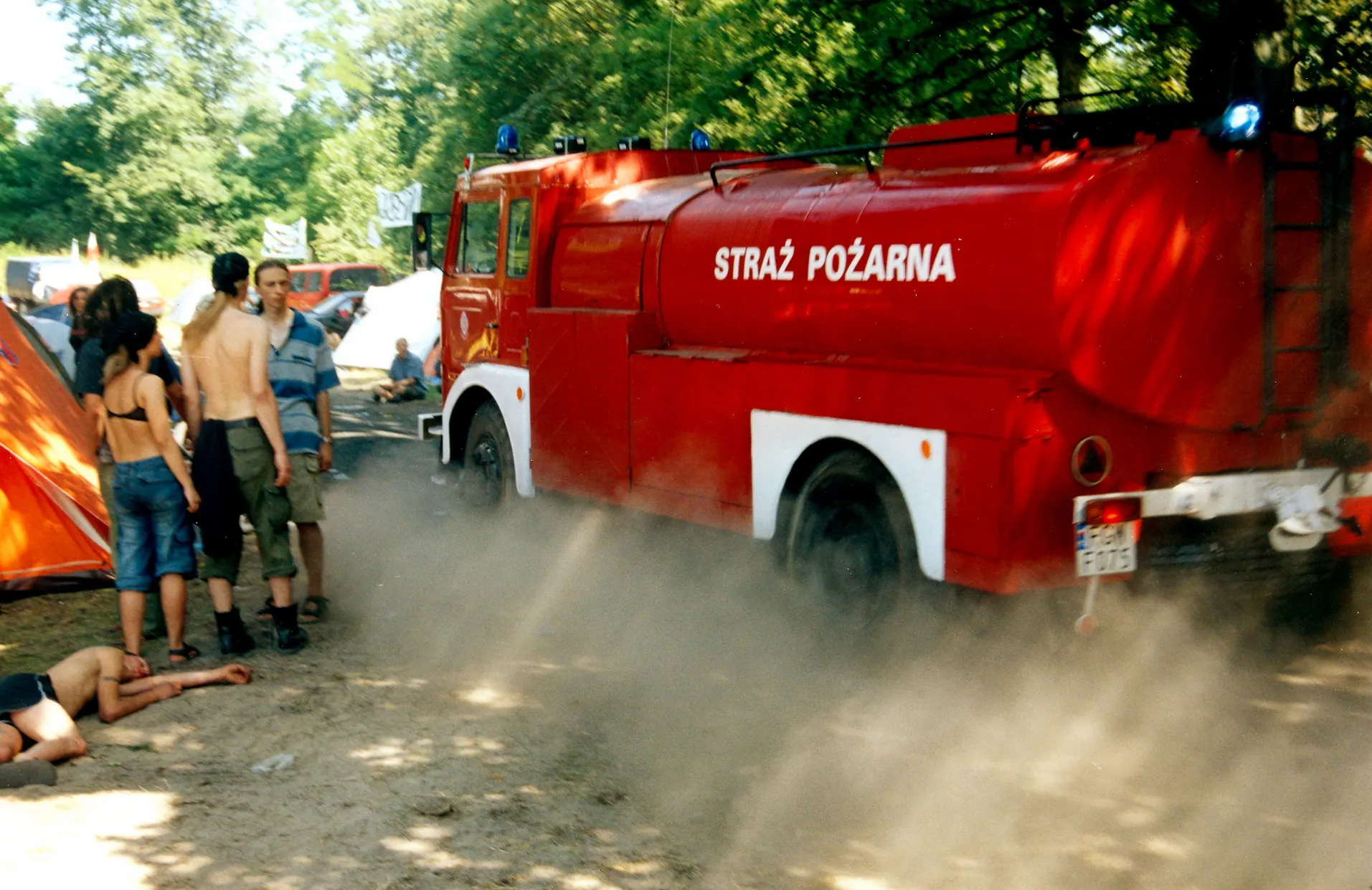 Feuerwehrauto fährt über eine staubige Piste auf dem Festivalgelände
