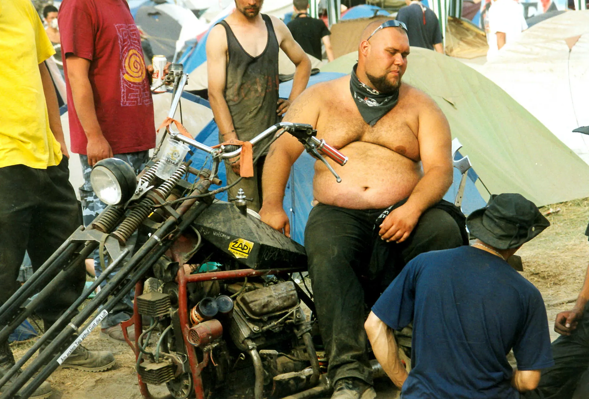 Mann sitzt auf einem umgebauten Motorrad im Zeltlager