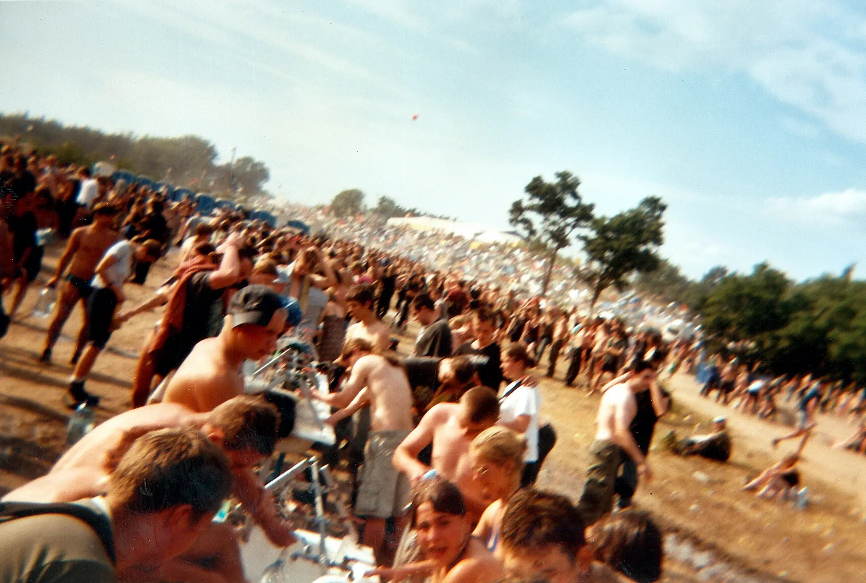 Weite Menschenmenge entlang eines Zauns auf dem Festivalgelände
