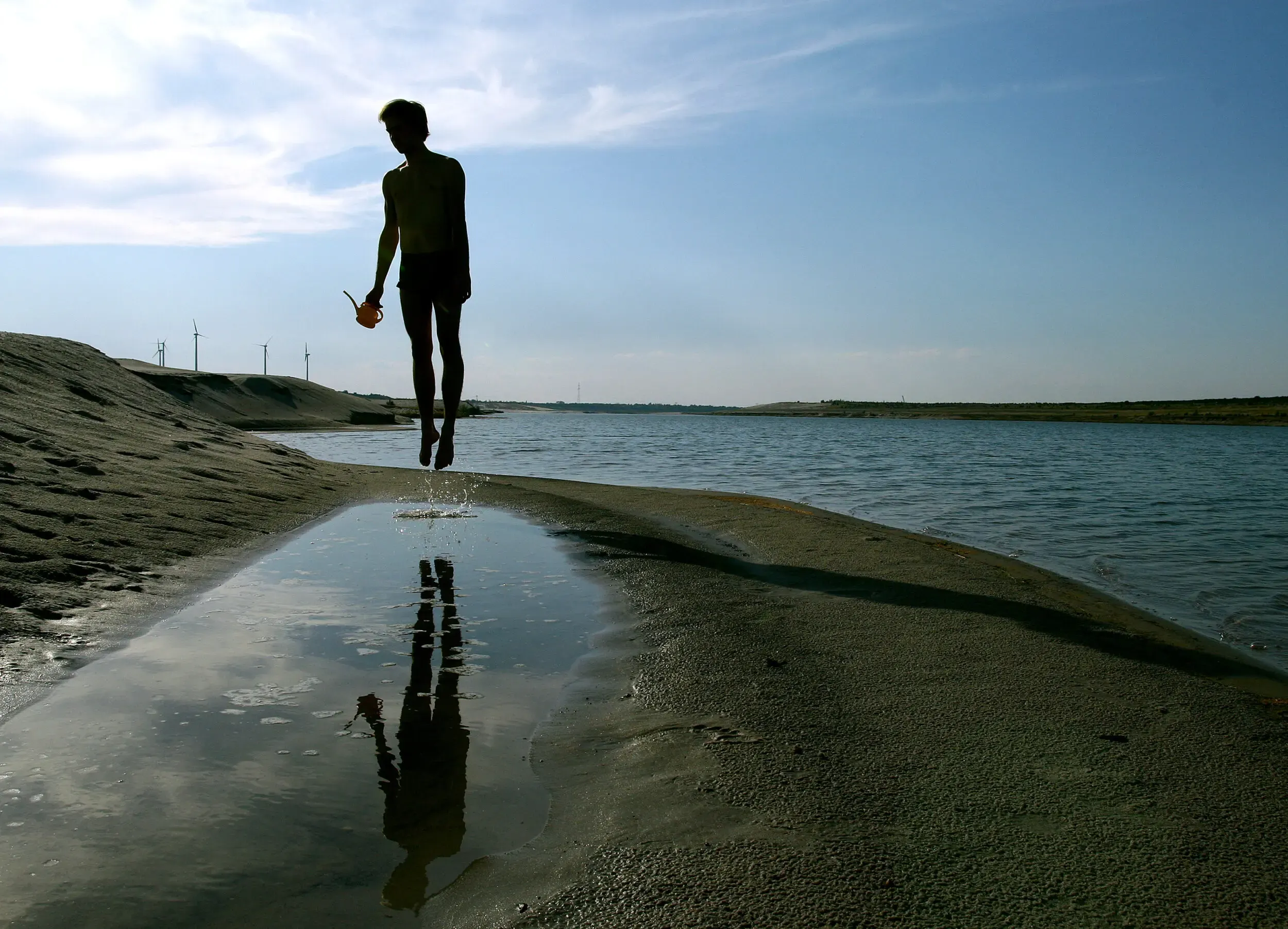 Silhouette einer Person auf spiegelndem Wasser