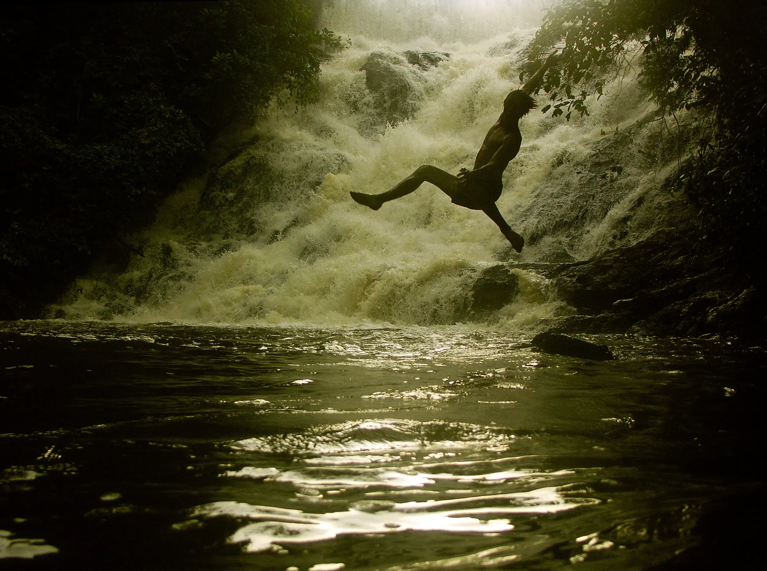 Person springt kopfüber in einen Wasserfall