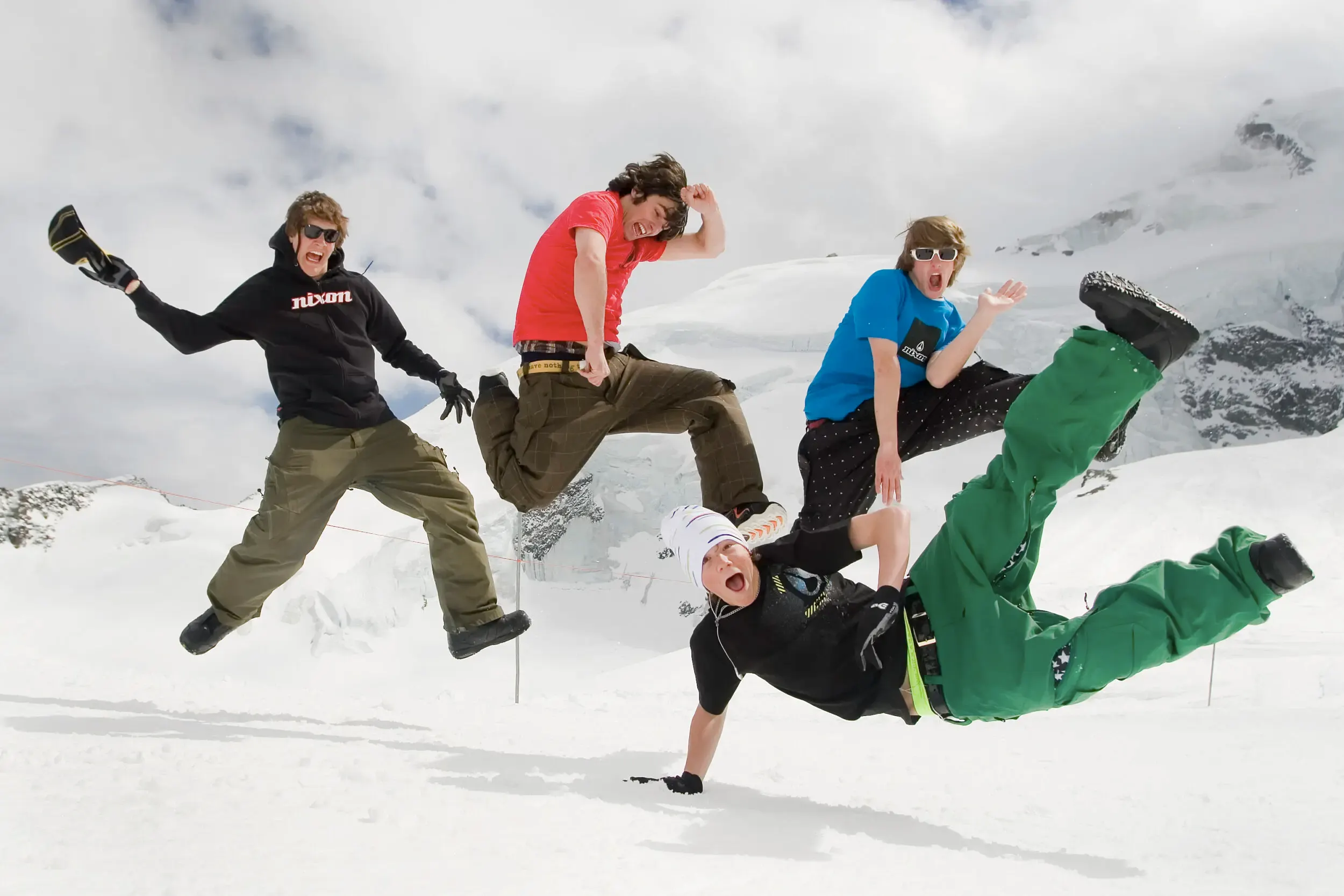 Vier Personen springen gleichzeitig im Schnee in die Luft