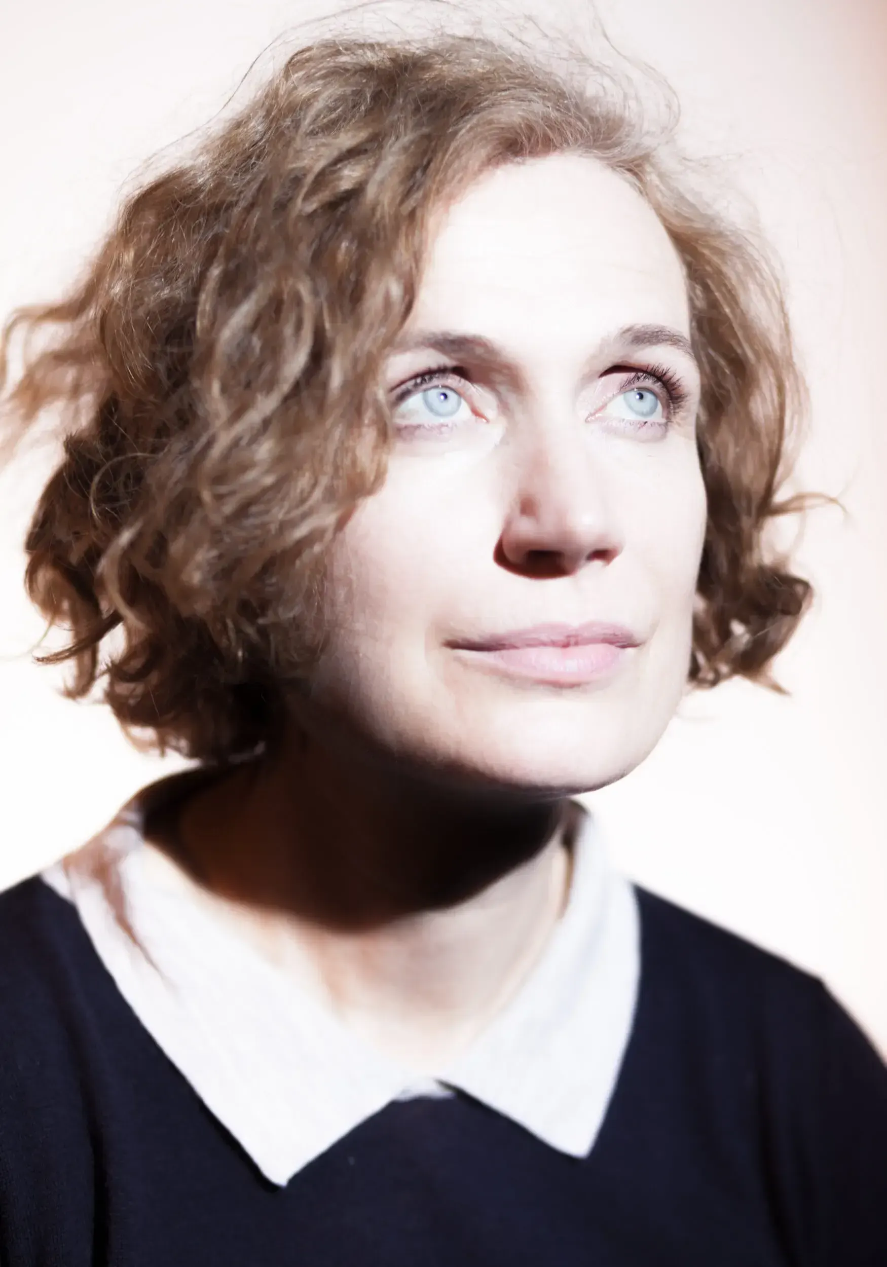 Portrait of Friederike Wagner looking upward in soft natural light.