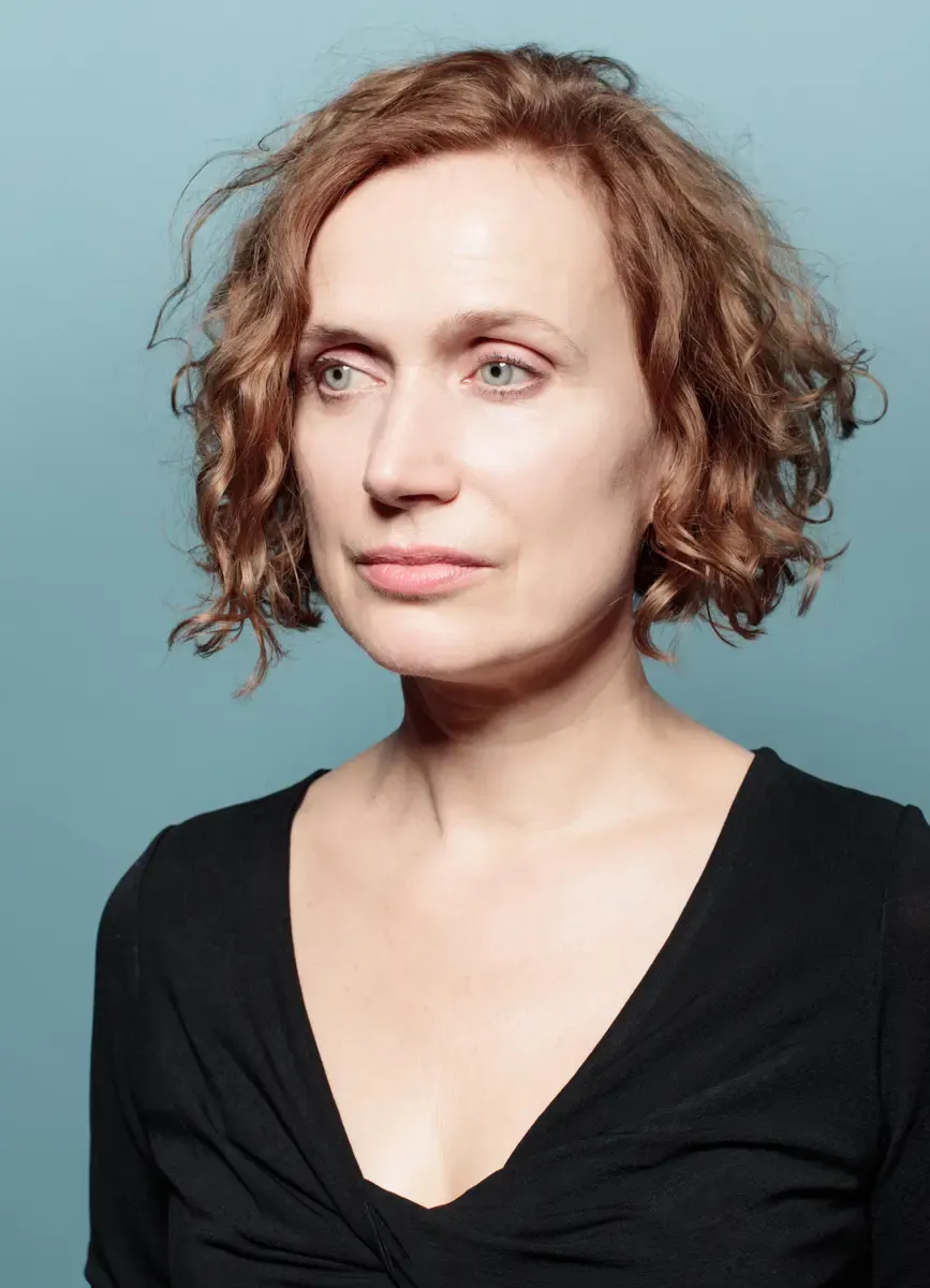 Portrait von Friederike Wagner vor türkisfarbenem Hintergrund