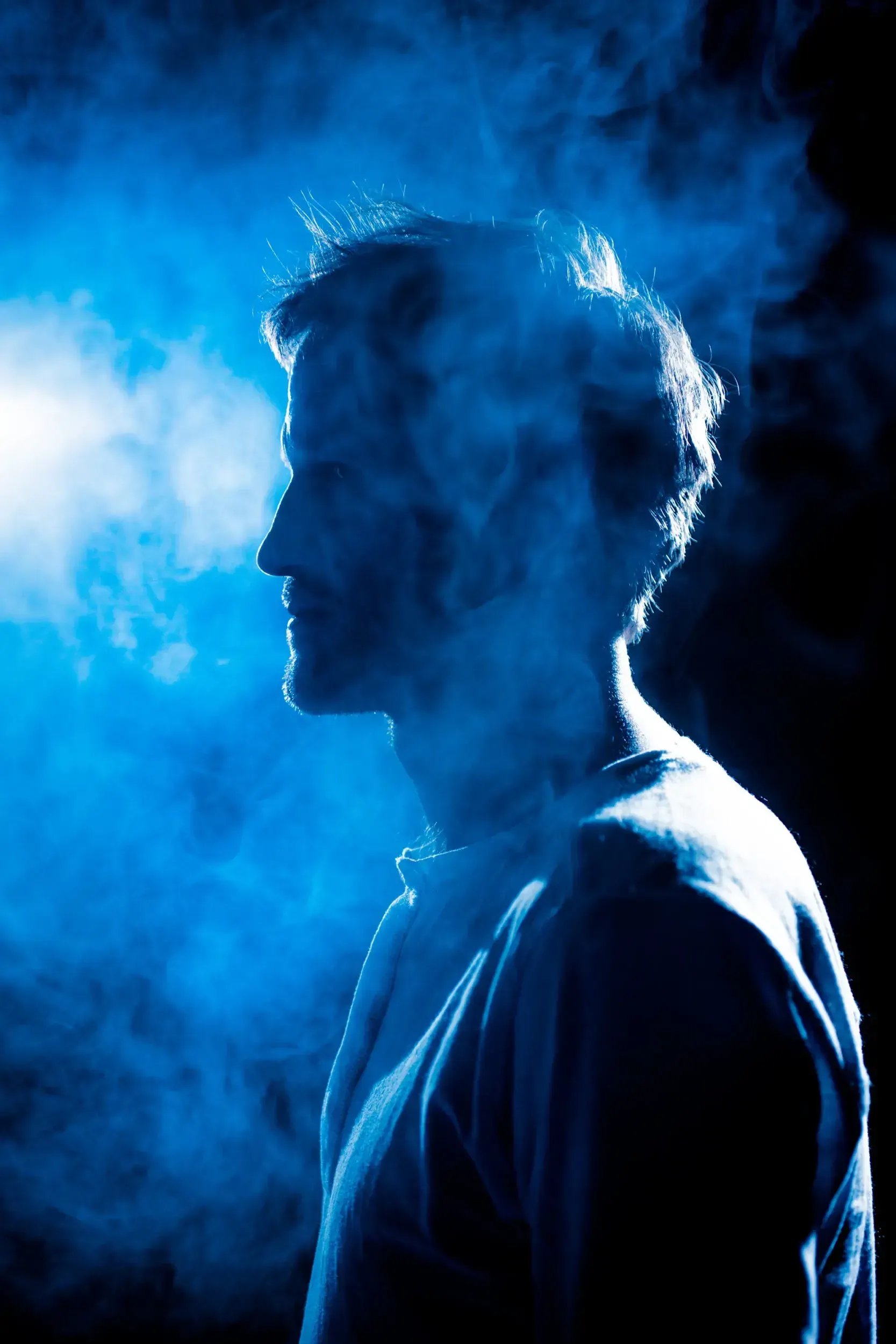 Silhouette profile portrait of Fritz Fenne surrounded by blue smoke.