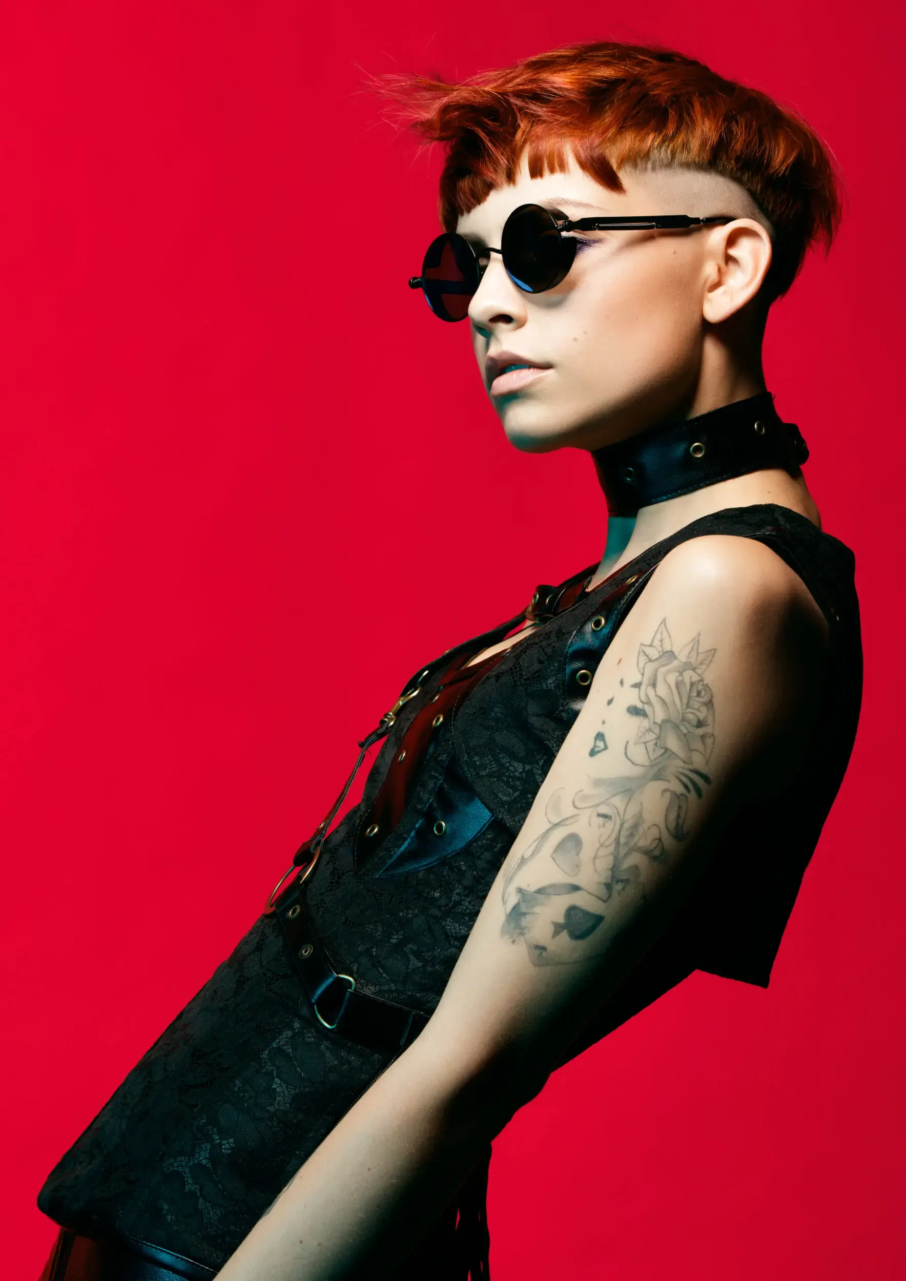 Frau mit Bob-Undercut-Frisur und Sonnenbrille vor rotem Hintergrund, German Hairdressing Award