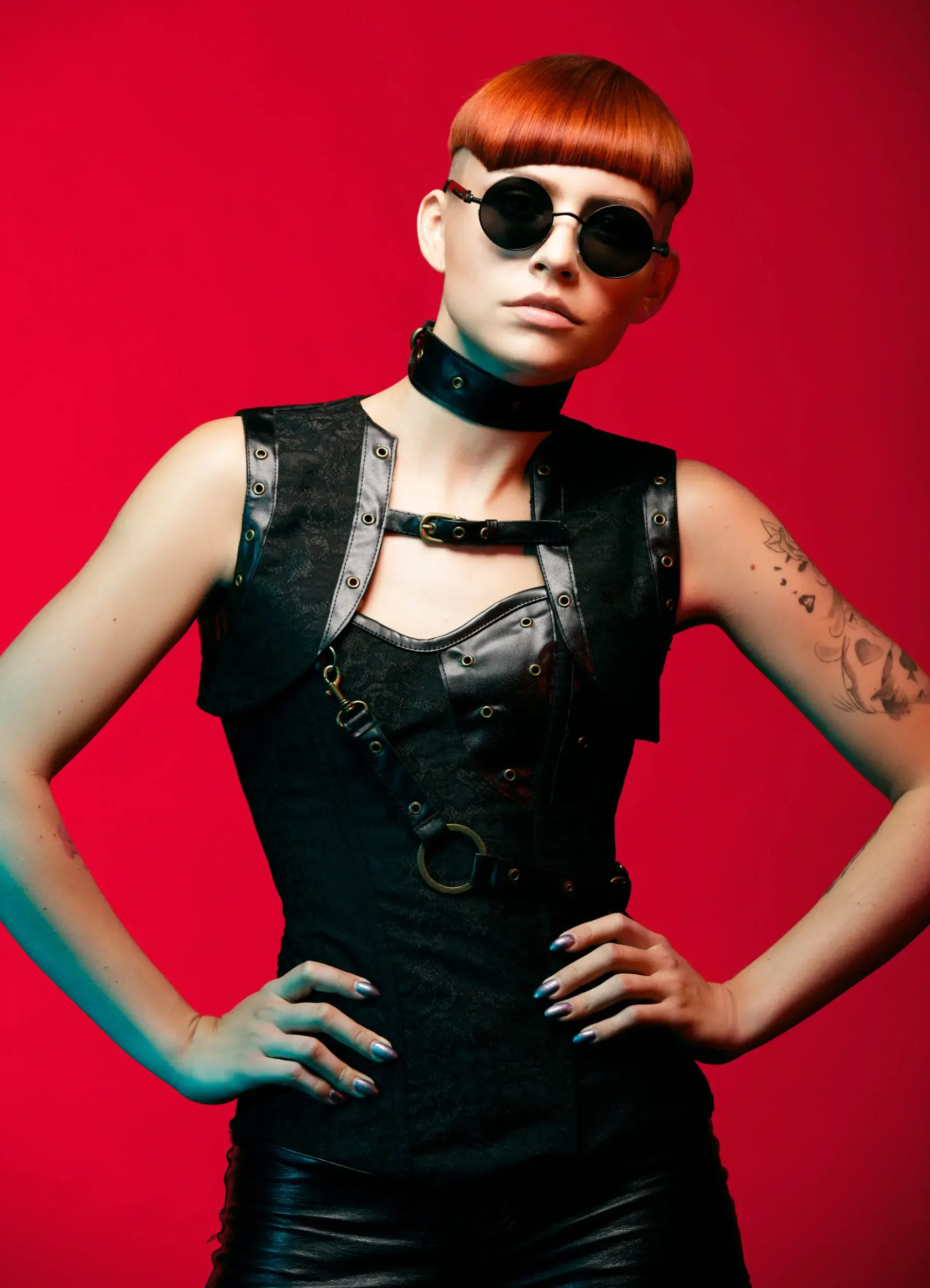 Frau mit orangefarbenem Pixie-Cut und Lederoutfit vor rotem Hintergrund, German Hairdressing Award