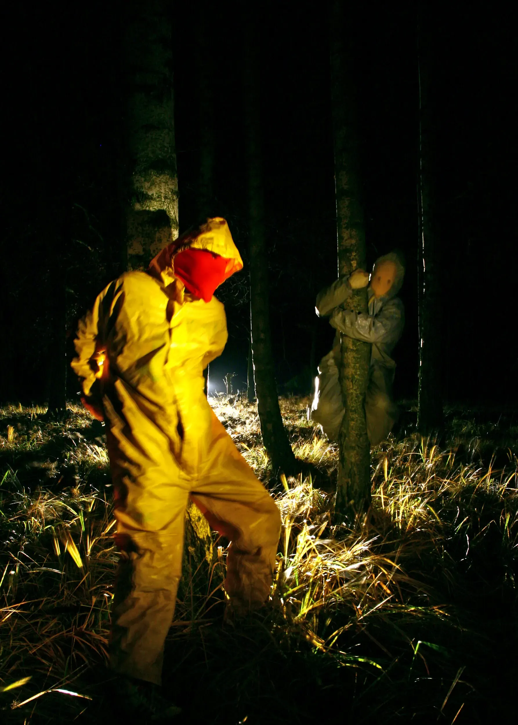 Zwei Personen im Schutzanzug im nächtlichen Wald, graugelb™