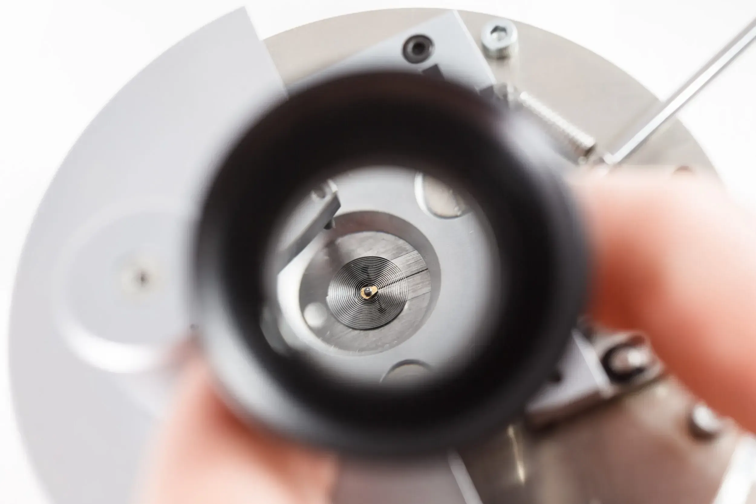 Close-up through a loupe of a watch movement being inspected at Greiner Vibrograf.