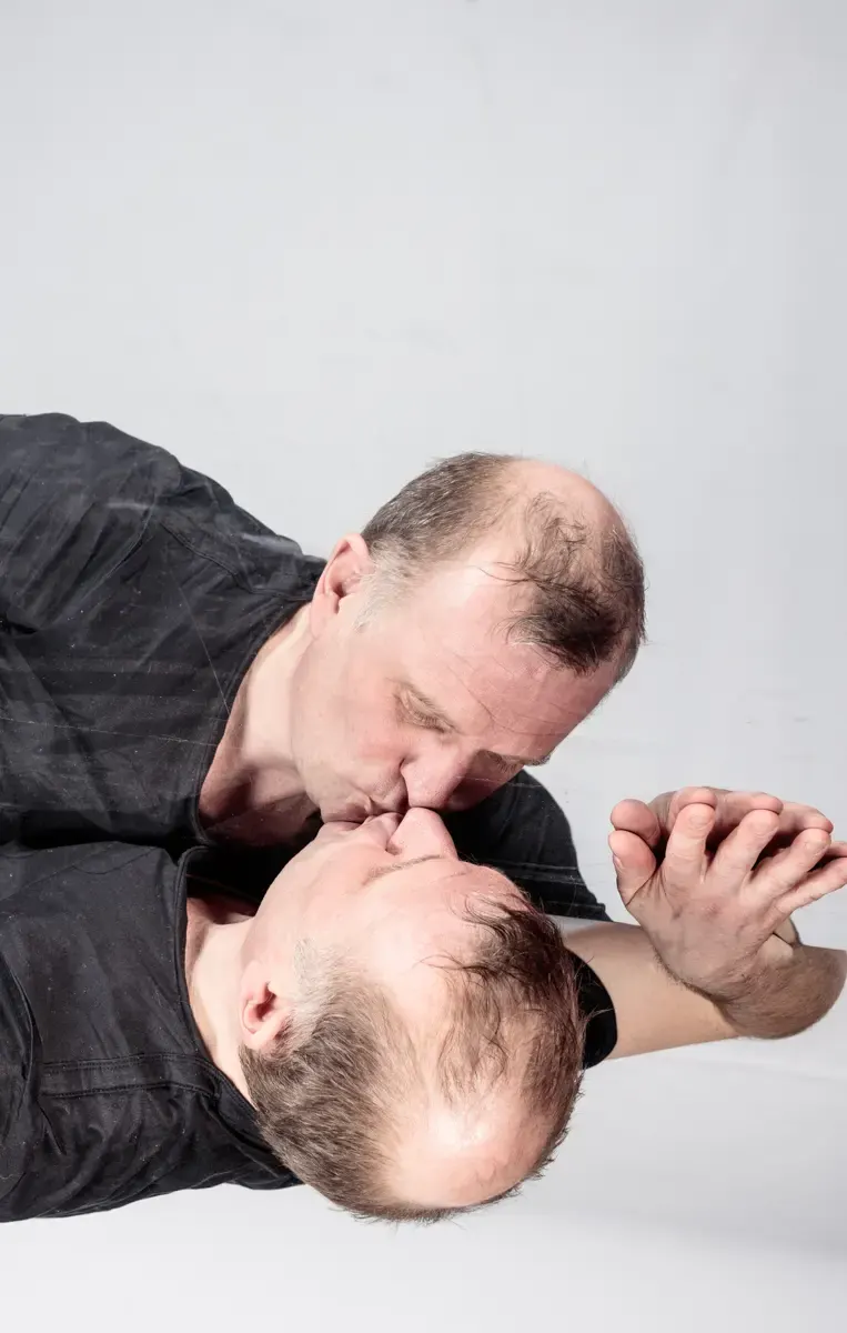 Bühnenfoto: Klaus Brömmelmeier mit einem weiteren Schauspieler, Gesicht an Gesicht