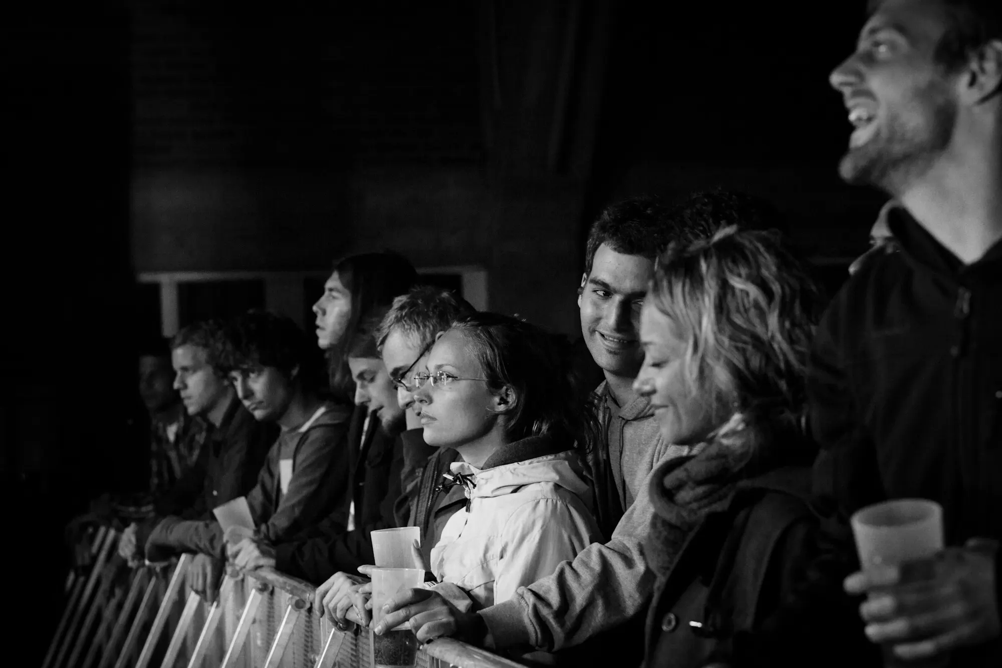Schwarzweissfoto: Konzertbesucher lachen und geniessen die Show