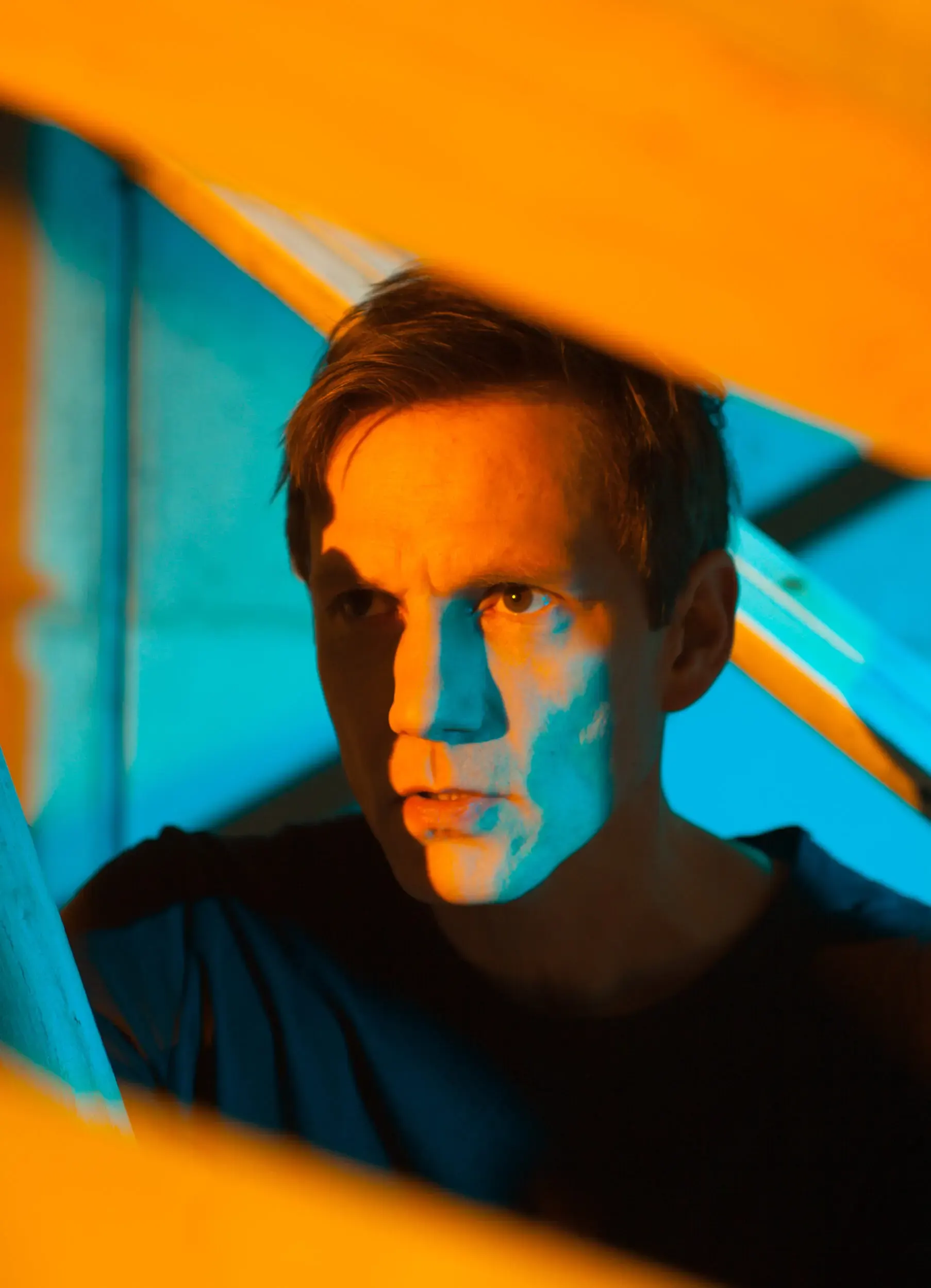 Portrait von Markus Scheumann mit türkis-orangem Grafikmuster überlagert