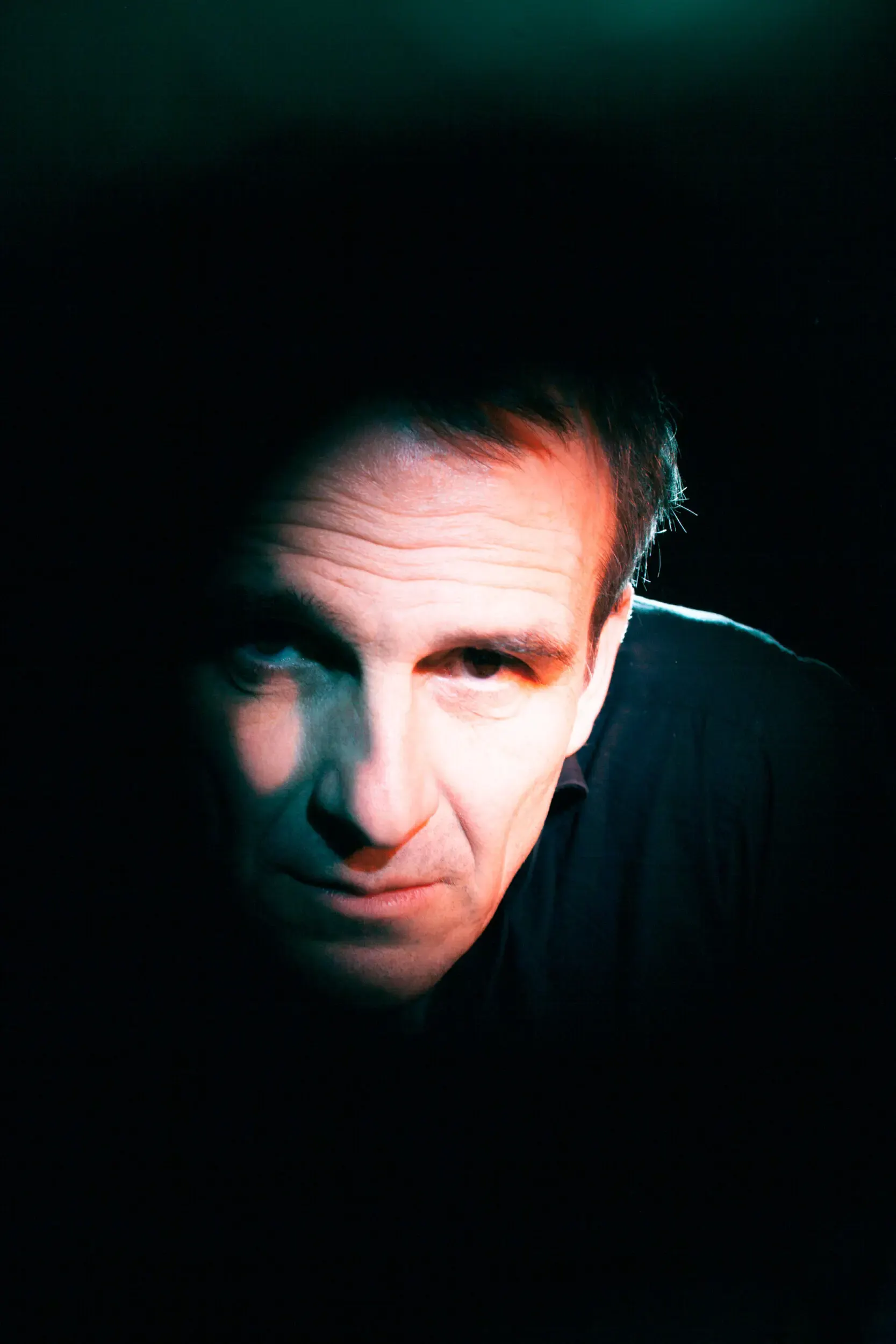 Nahaufnahme-Portrait von Matthias Neukirch vor dunklem Hintergrund