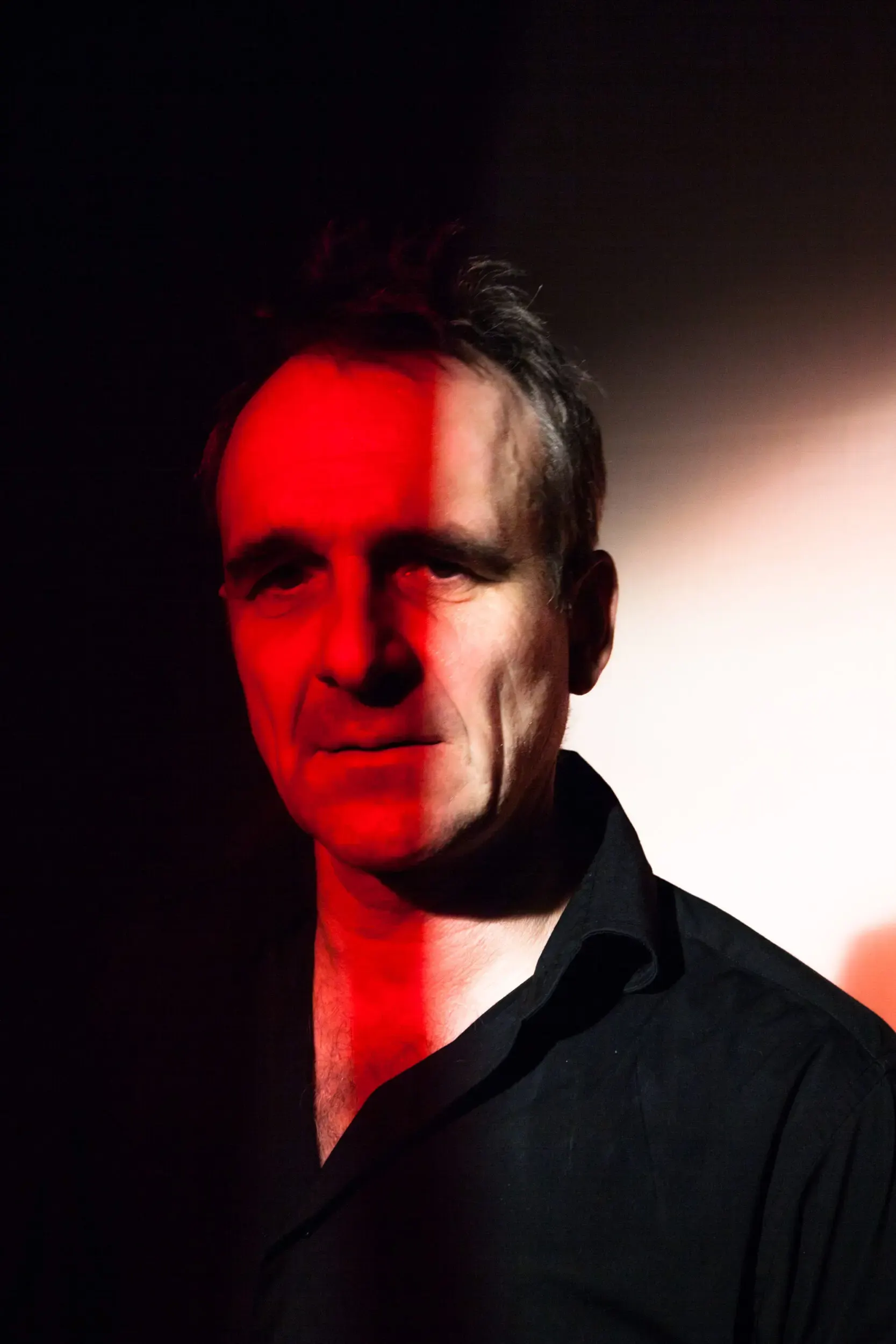 Portrait von Matthias Neukirch mit rotem Streiflicht vor dunklem Hintergrund