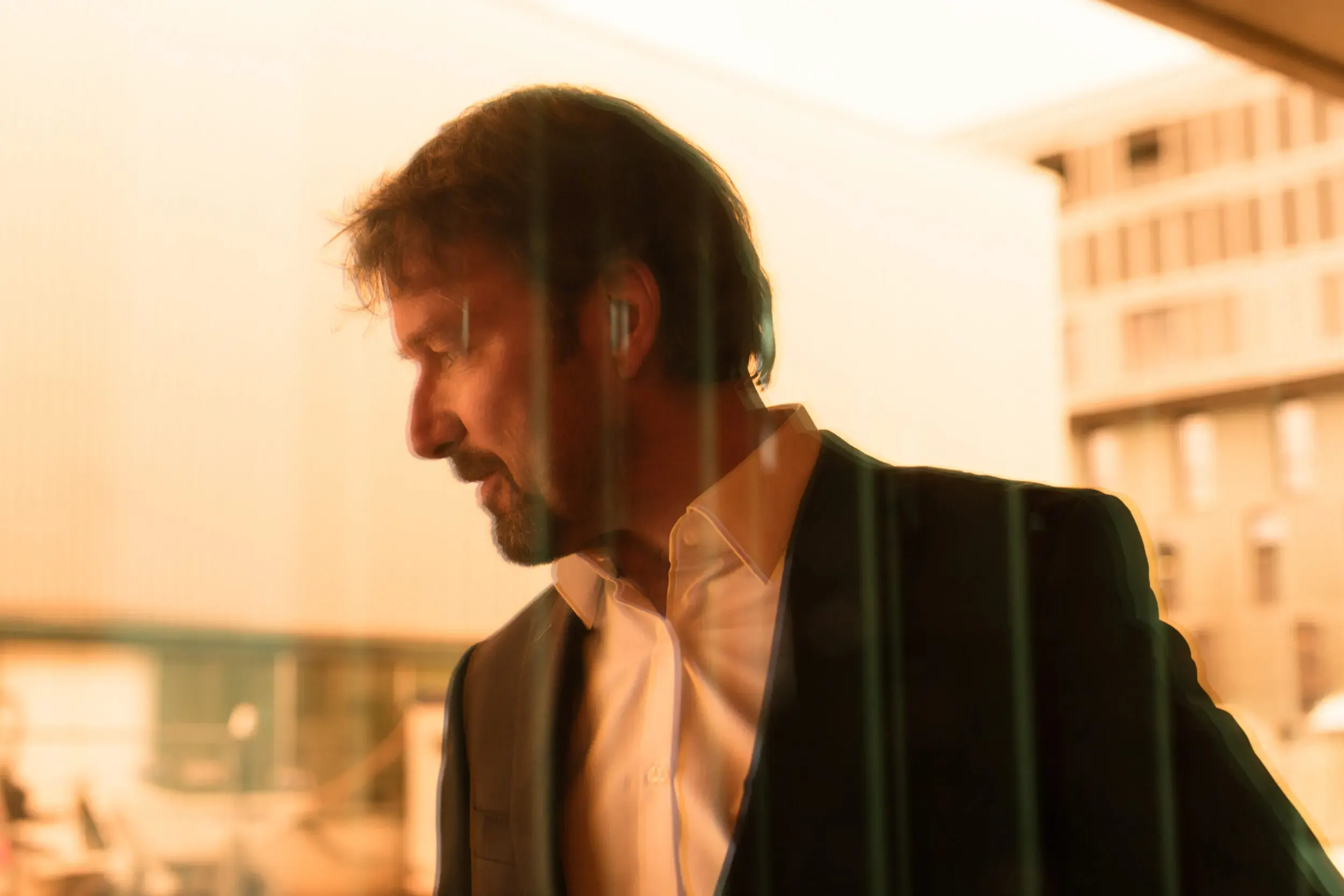 Michael Neuenschwander im Gegenlicht vor einem Bürogebäude