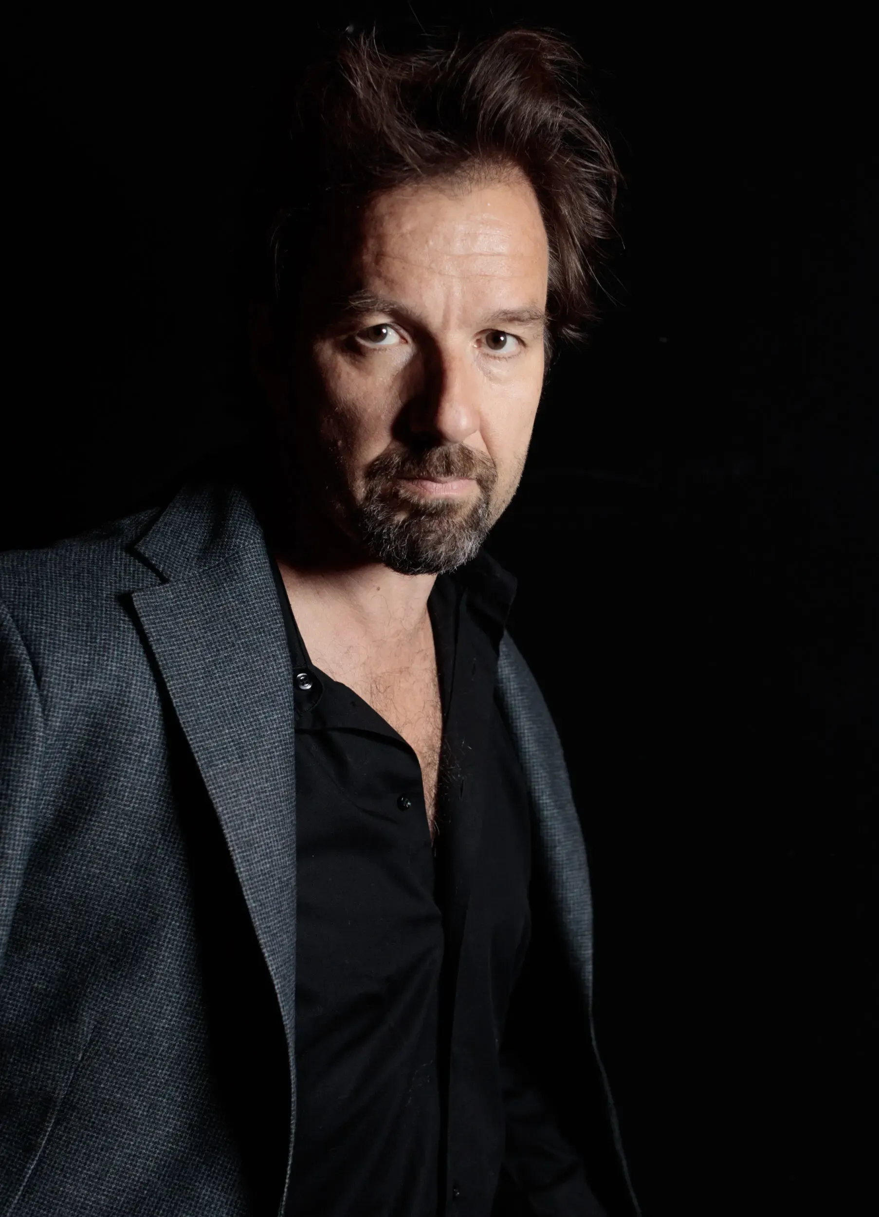 Dramatisches Portrait von Michael Neuenschwander vor dunklem Hintergrund