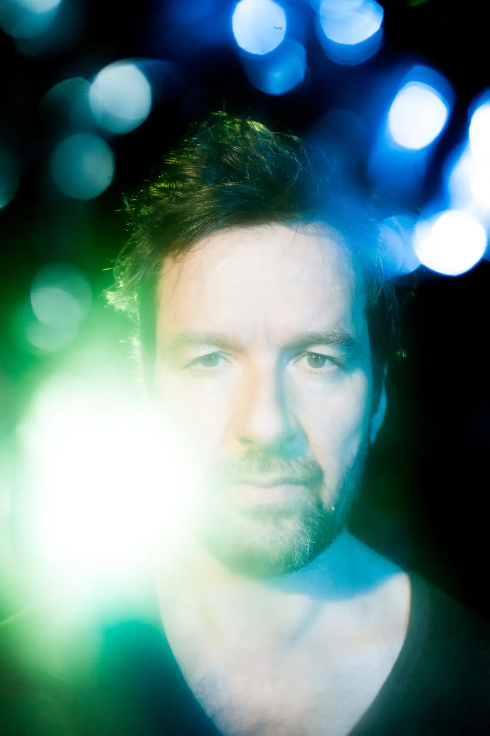 Portrait von Michael Neuenschwander mit türkisfarbenem Bokeh-Licht