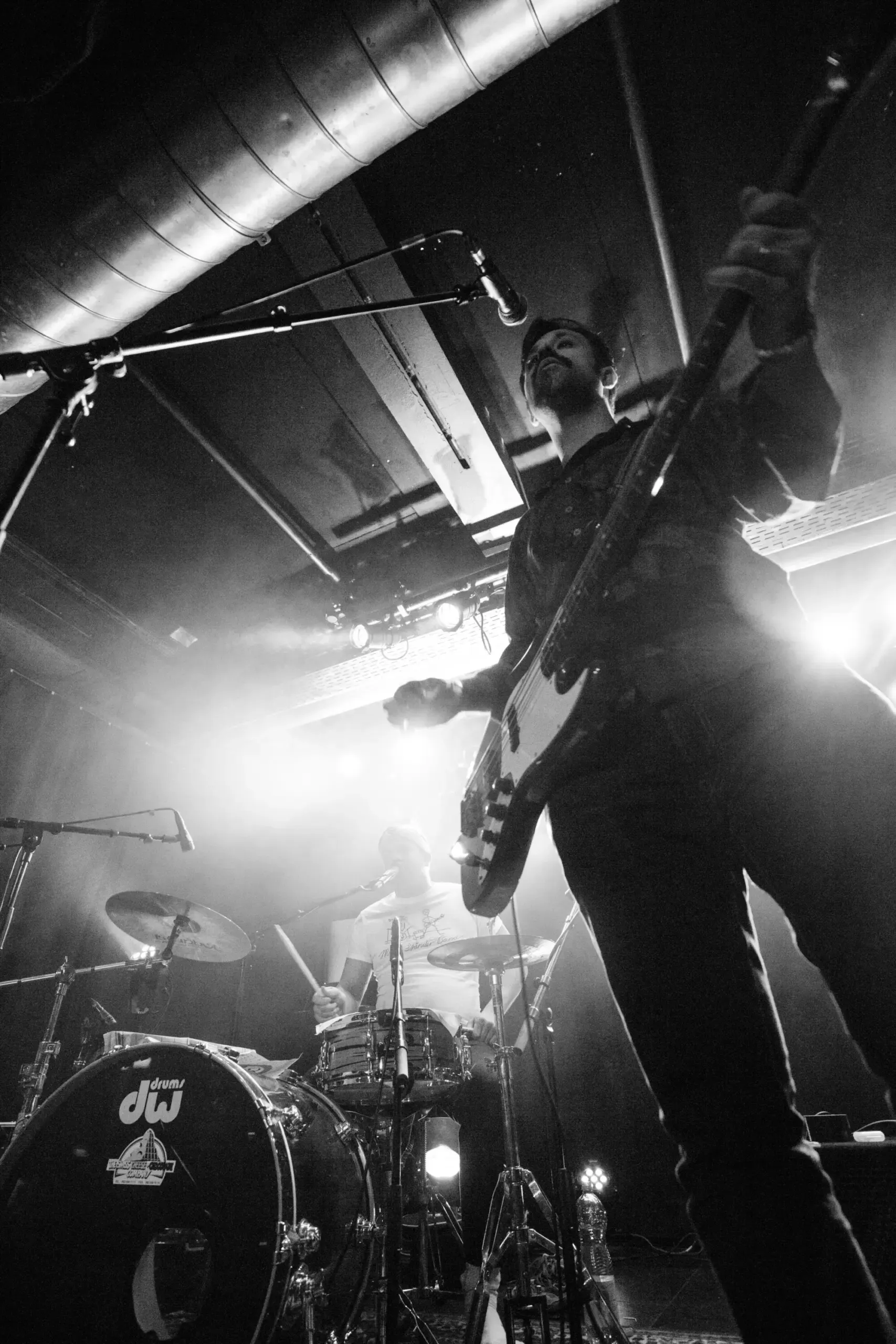 Schwarzweissfoto: Gitarrist der Mike-Ständer-Band springt auf der Bühne