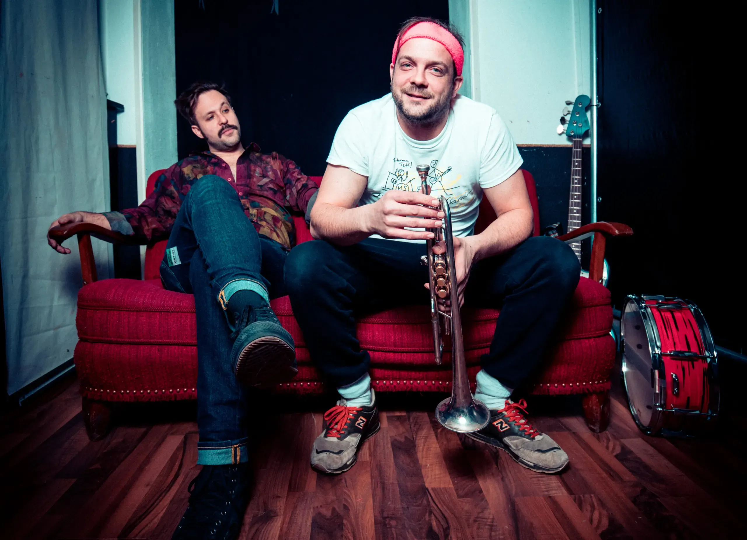 Bandmitglied mit Trompete auf rotem Sofa