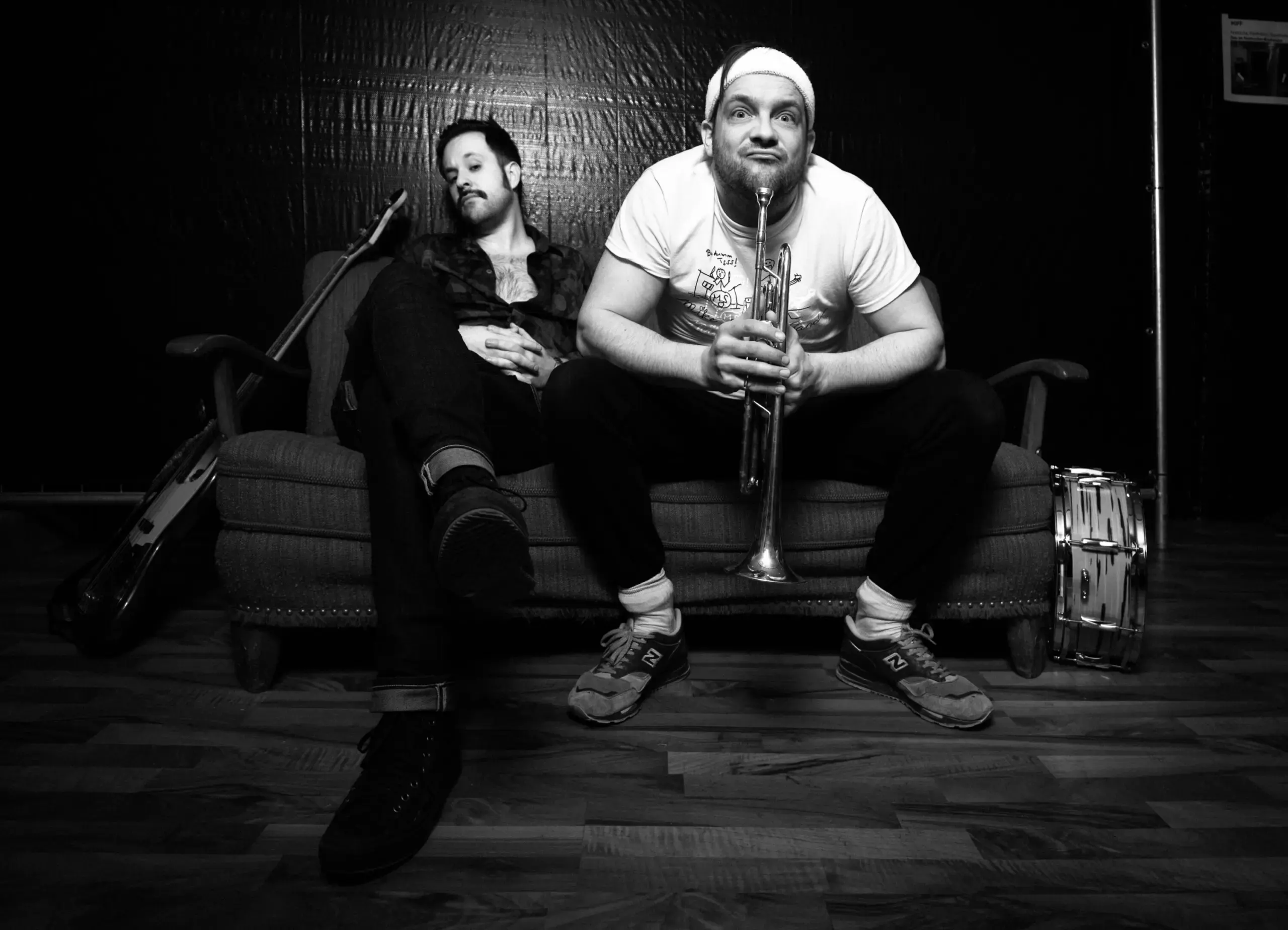 Schwarzweissfoto: Bandmitglied mit Trompete auf dem Sofa