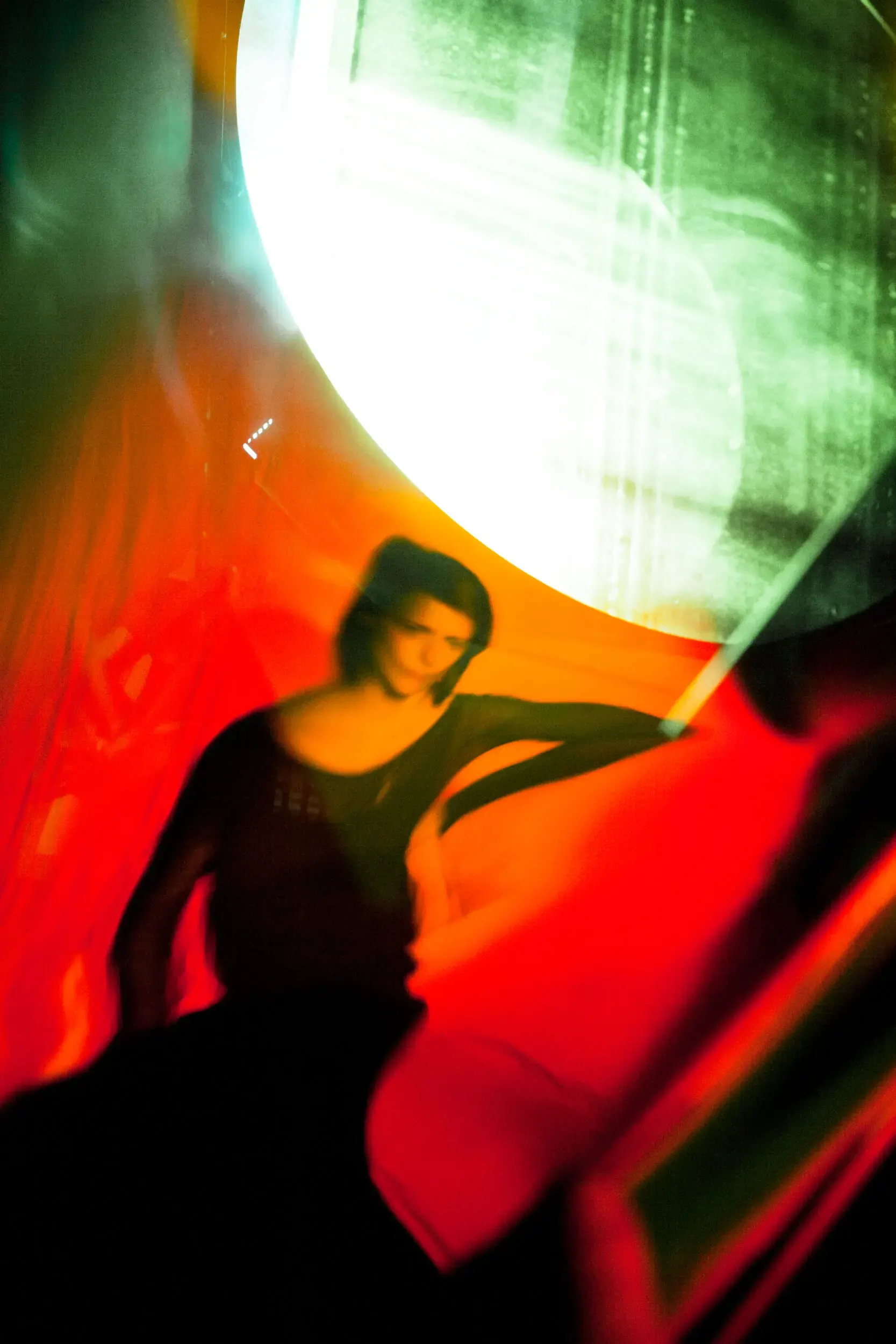 Silhouette einer Frau vor leuchtendem rundem Licht, Mood