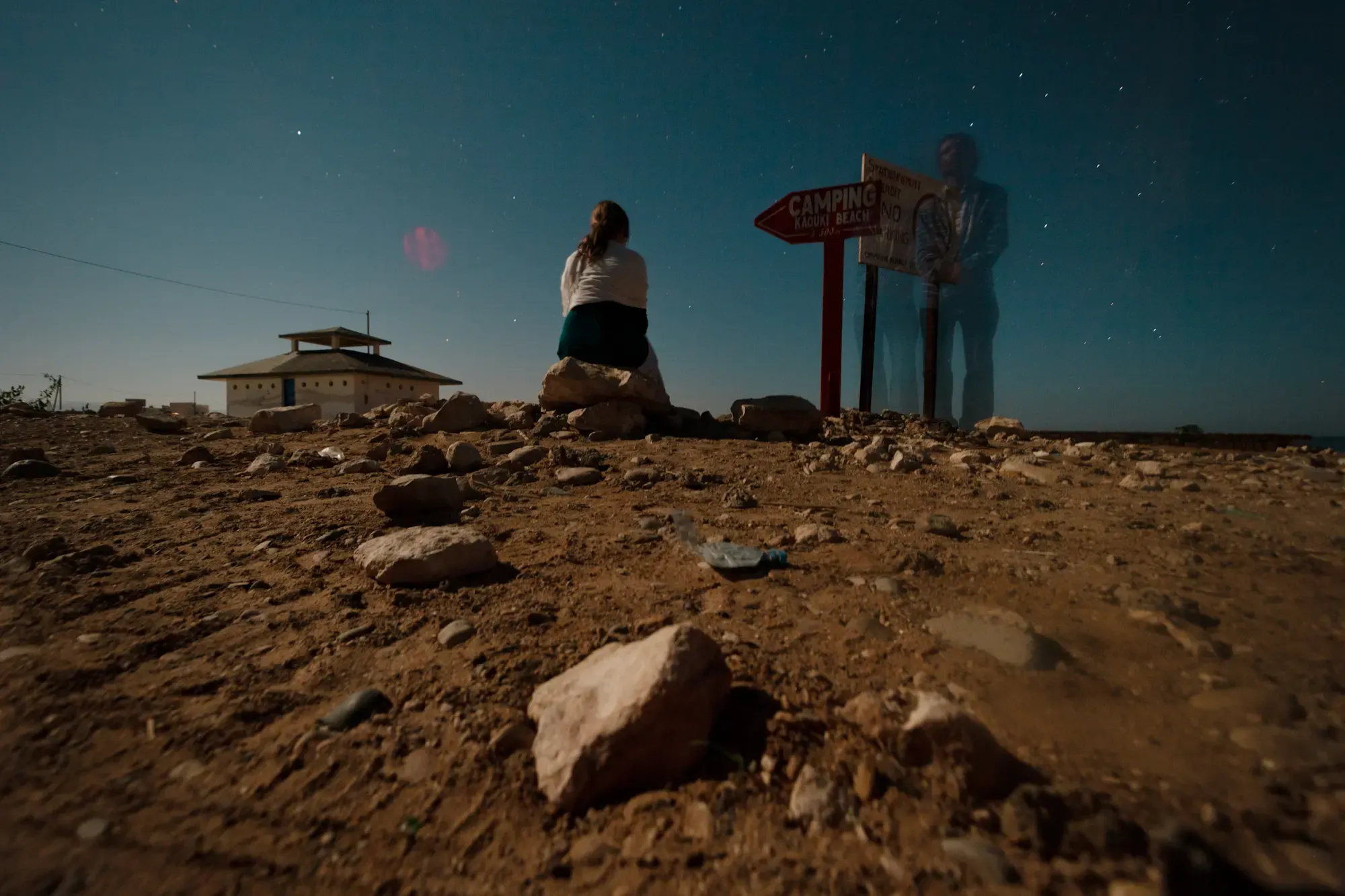 Person am Strand bei einem Wegweiser, Morocco Experience