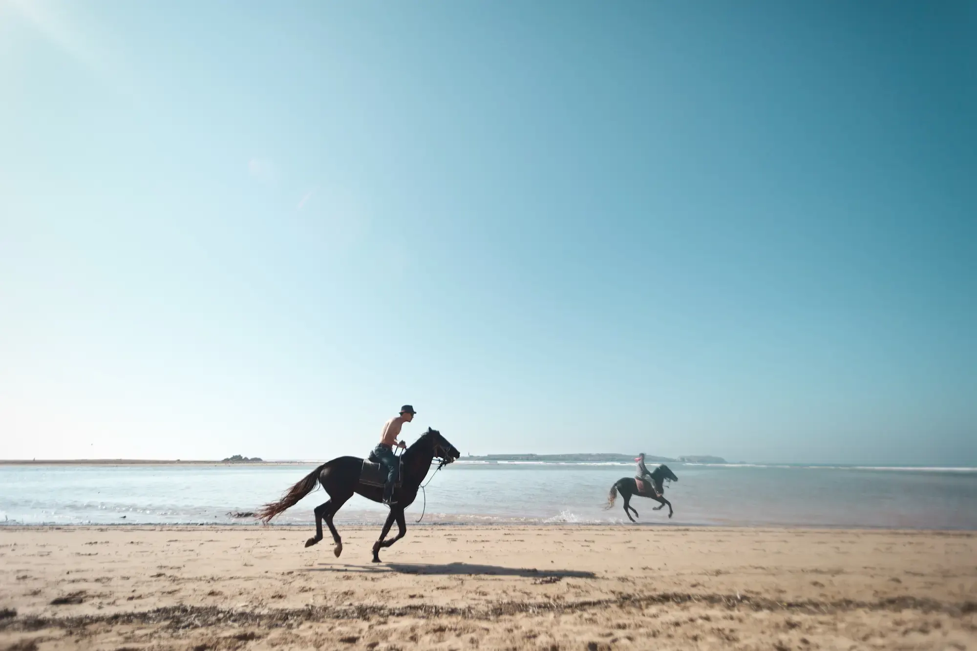 Zwei Reiter galoppieren am Strand, Morocco Experience