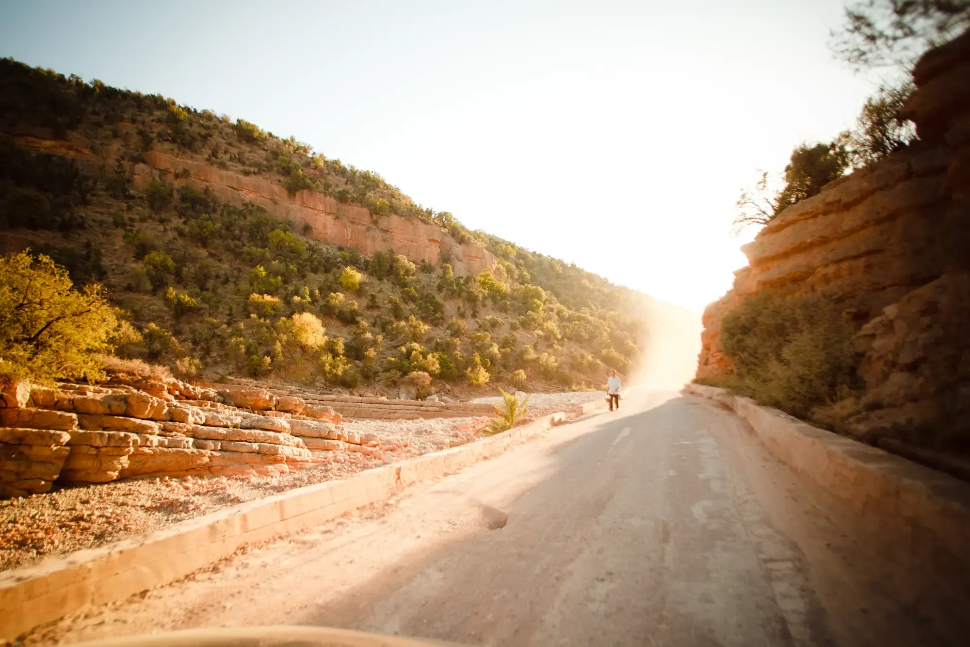 Strasse durch Hügellandschaft bei Sonnenuntergang, Morocco Experience