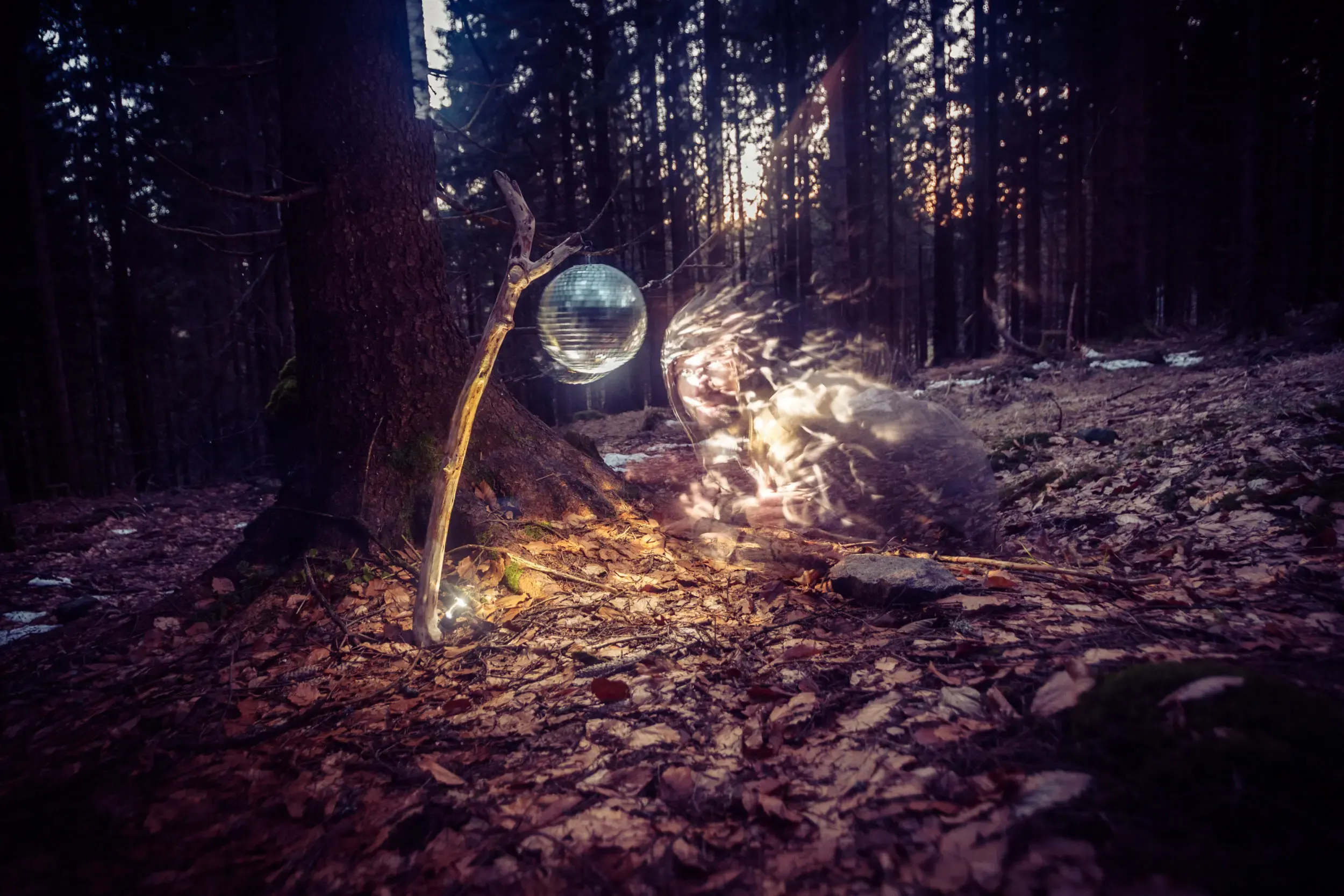 Surreale Gestalt mit leuchtender Kugel im nächtlichen Wald, Silvester