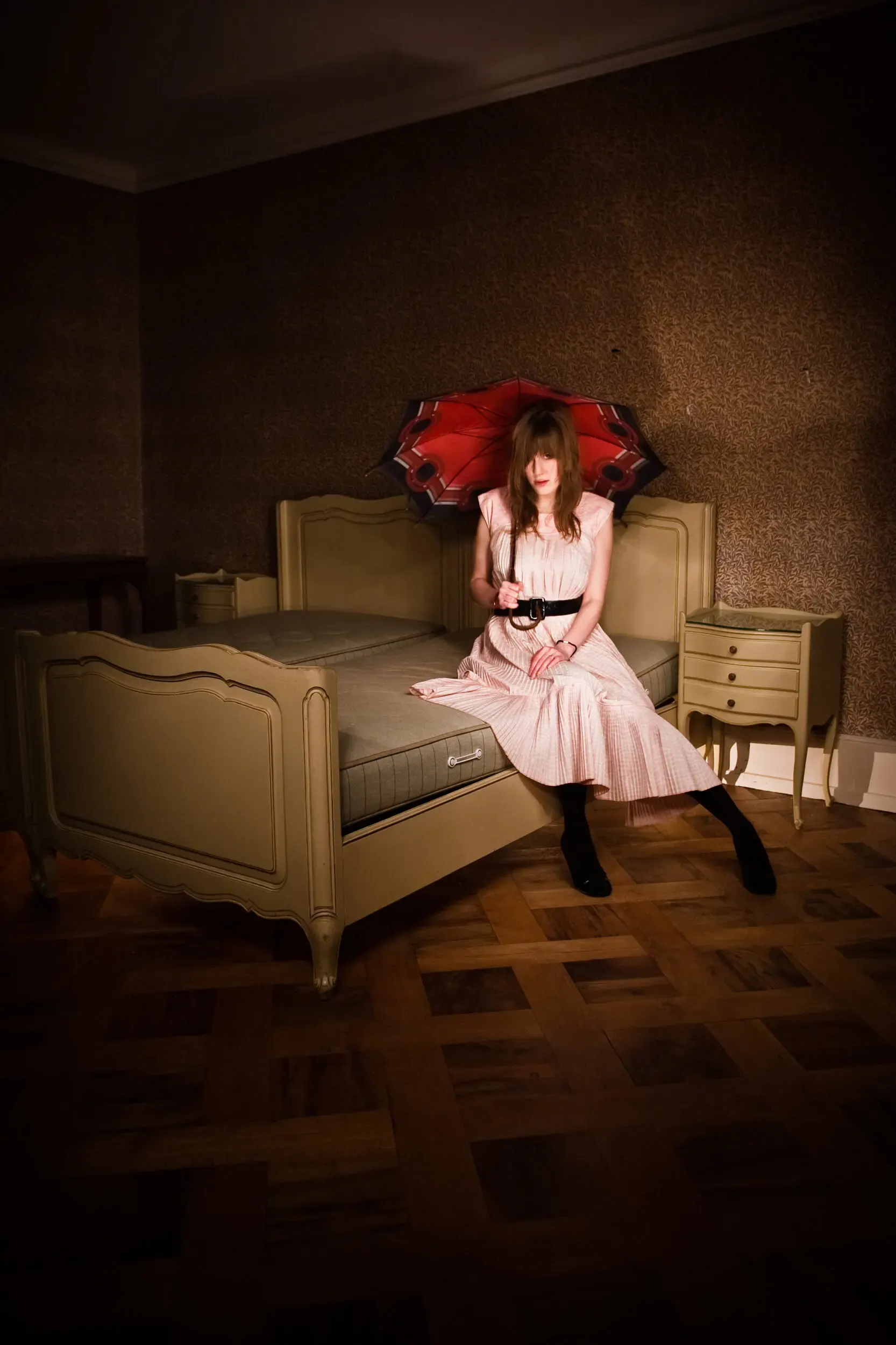 Mädchen im rosa Kleid sitzt auf einem Bett bei Nacht, Nightshift