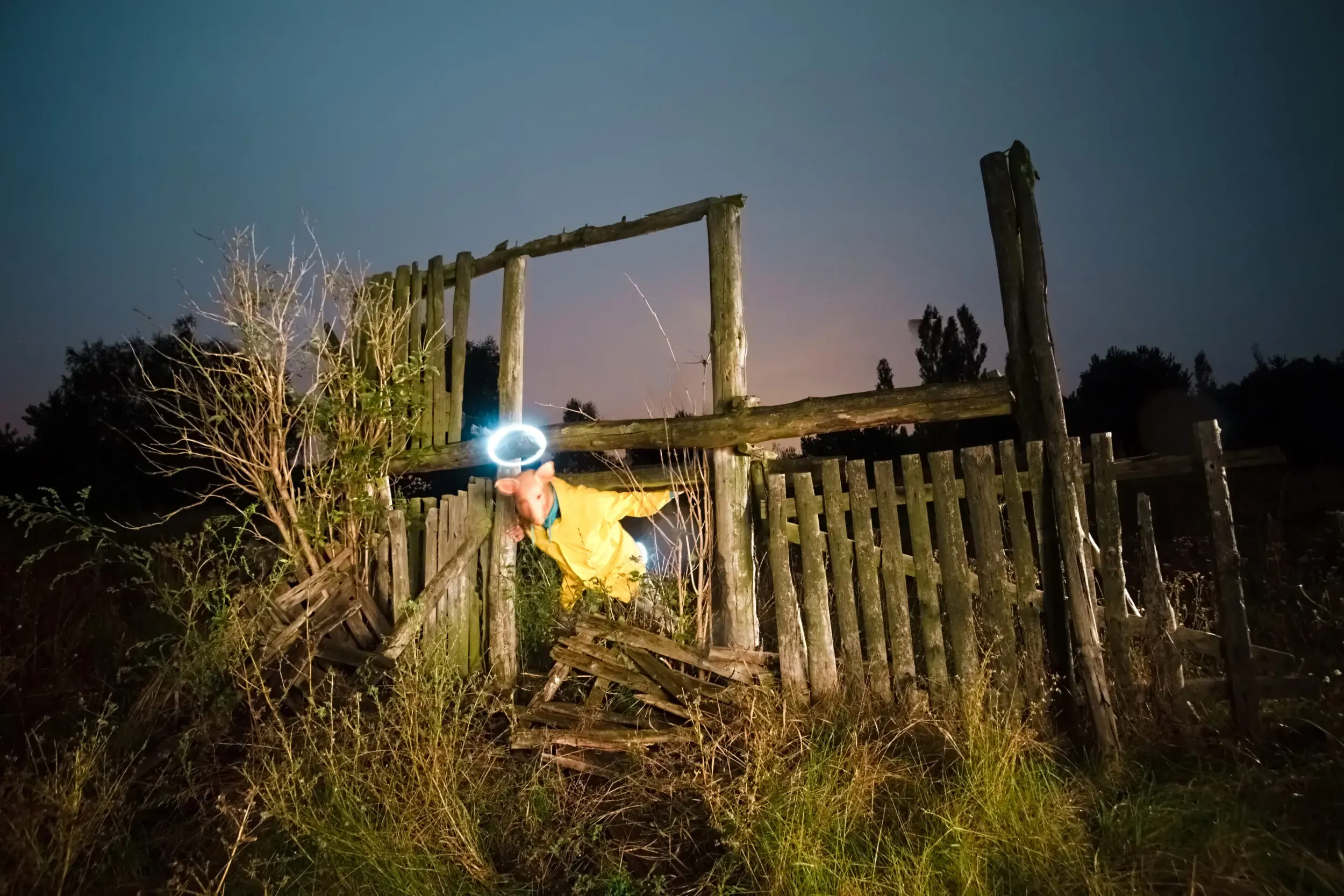 Person mit leuchtendem Licht in verwilderten Ruinen bei Nacht, Nightshift