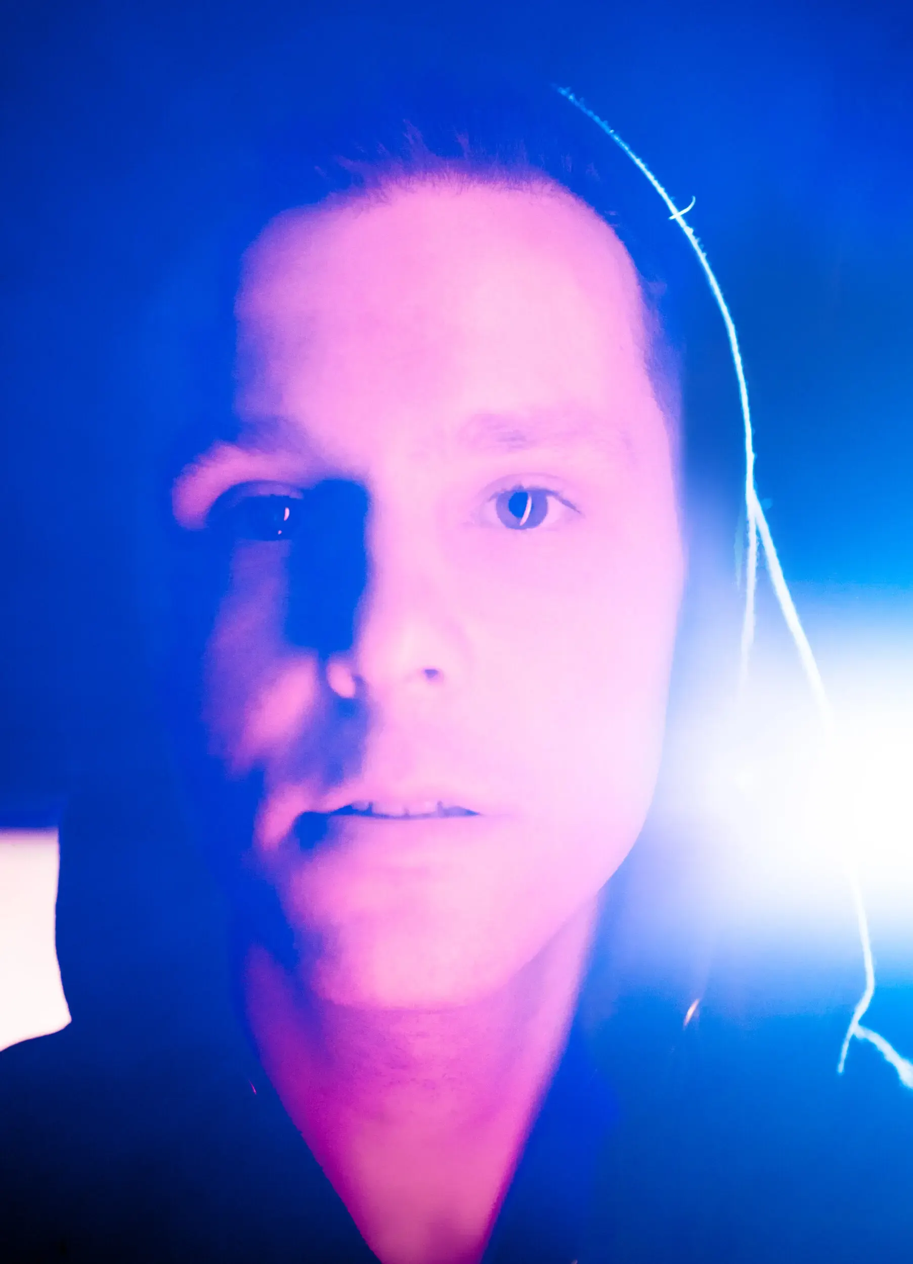 Nahaufnahme-Portrait von Nils Kahnwald im blauen Gegenlicht