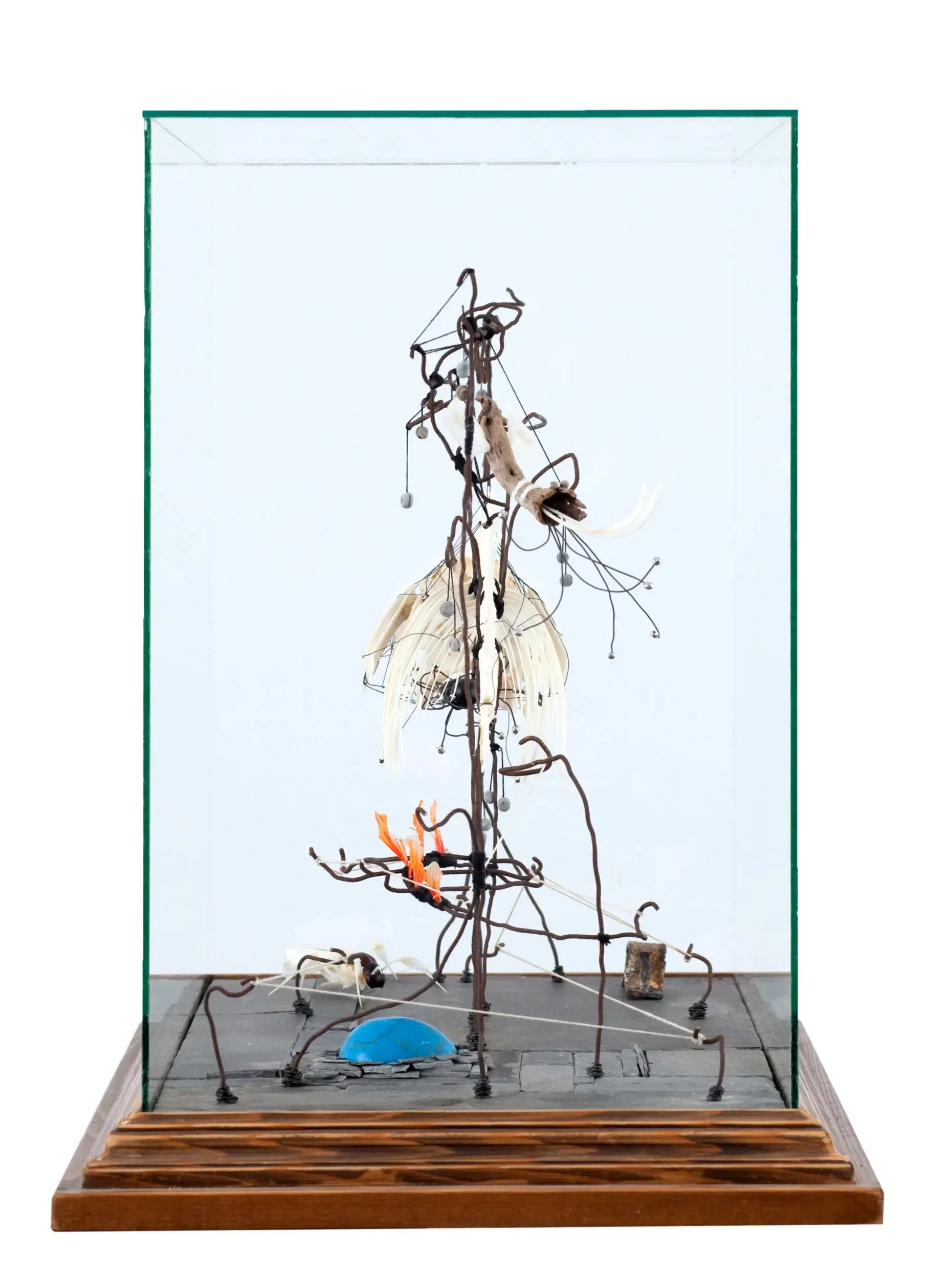 Drahtfigur in Glasvitrine mit blauem Farbpunkt am Boden