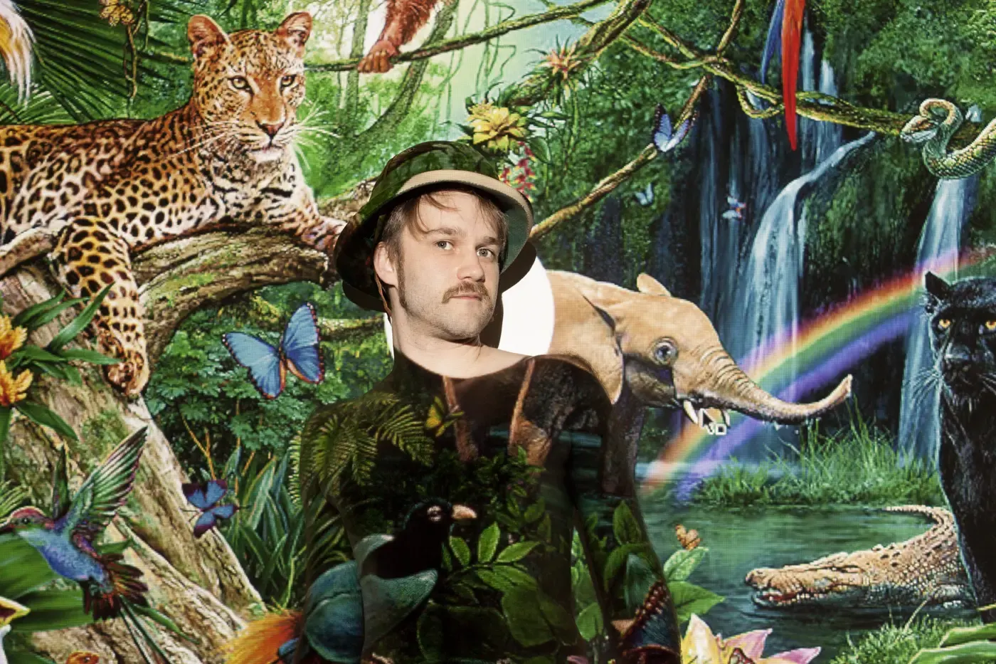 Surreale Fotomontage: Mann mit Leopard im Dschungel vor Wasserfall und Regenbogen