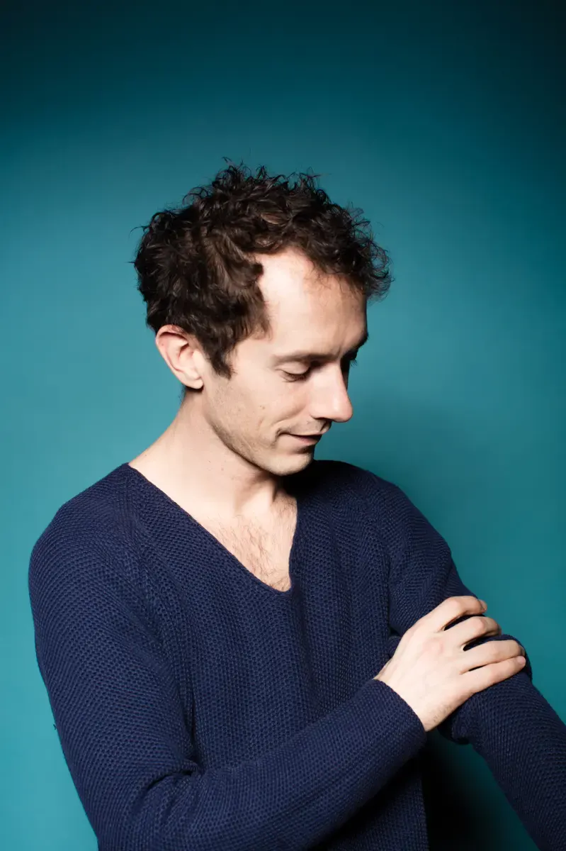 Portrait eines Mannes im blauen Pullover, der seitlich blickt